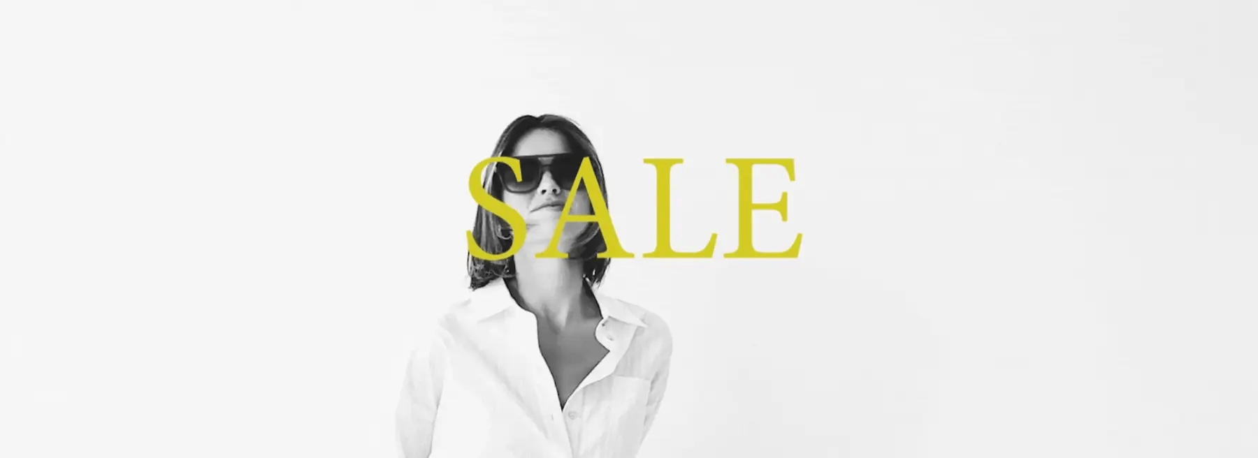 White text over a building facade reads "SALE just dropped," with black ornate doors in the background.