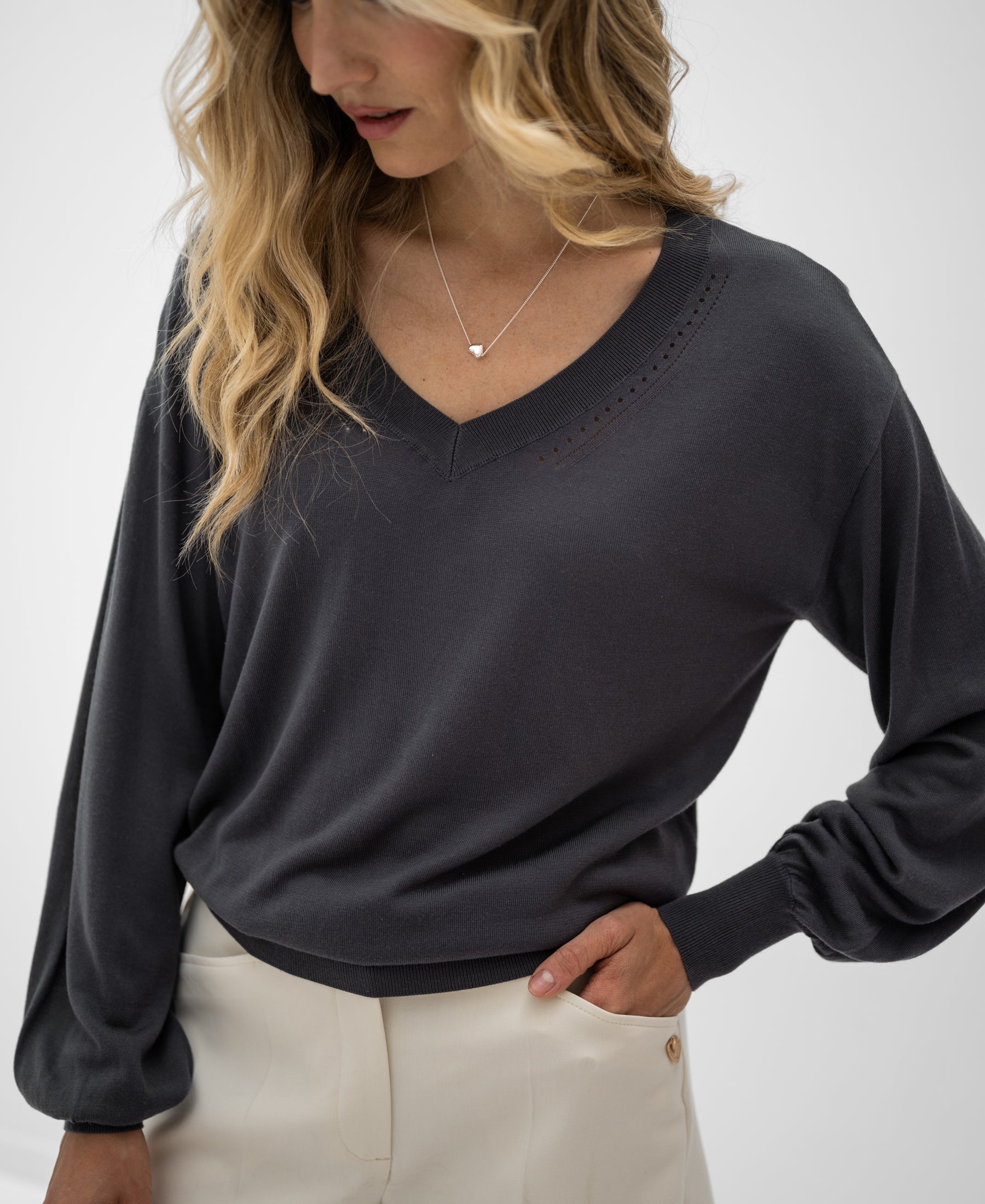 Dark V-neck sweater shown on a person, photographed against a plain background.