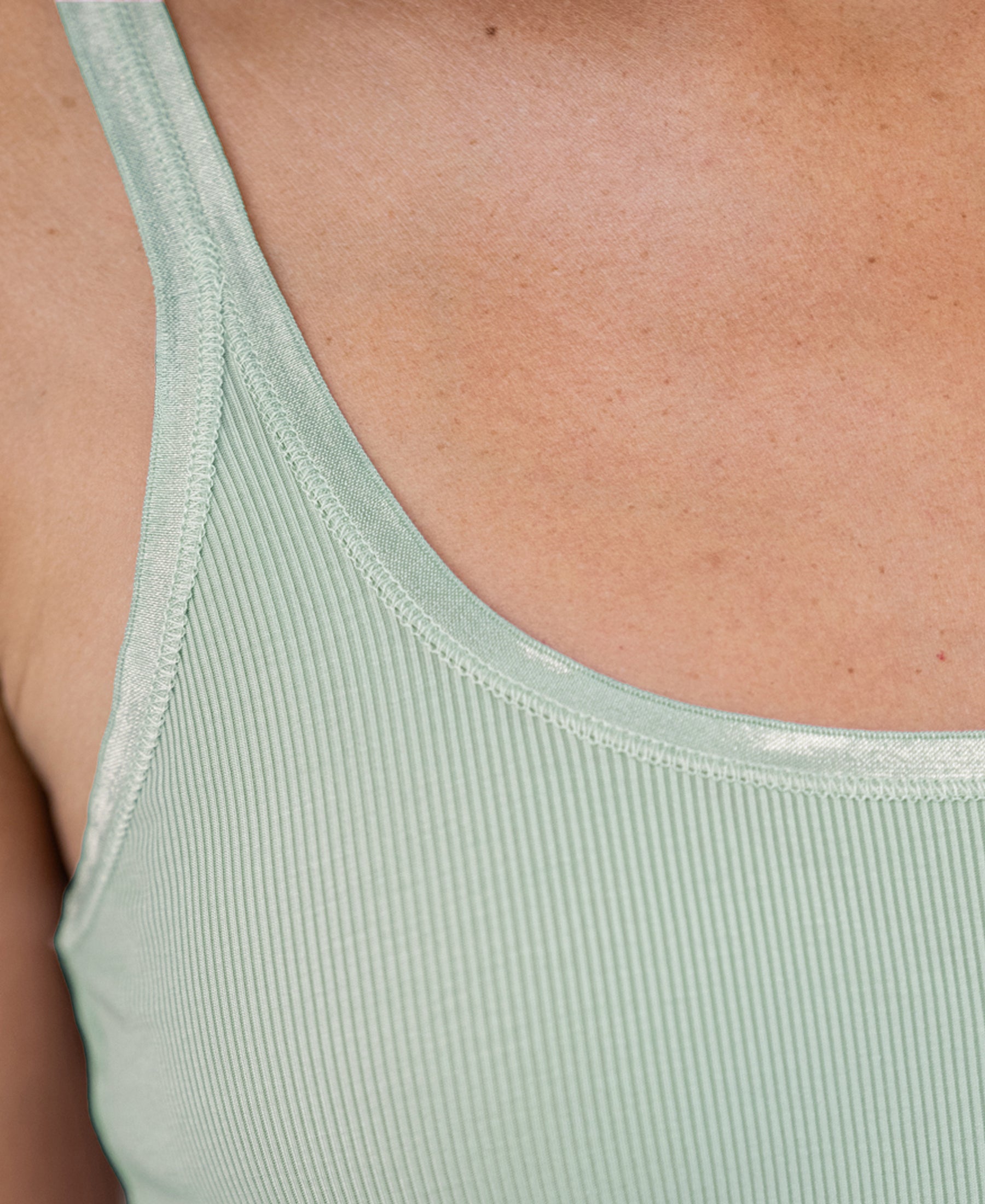 Close-up of the Luxe Cami top in light mist green, showing the strap and upper chest.
