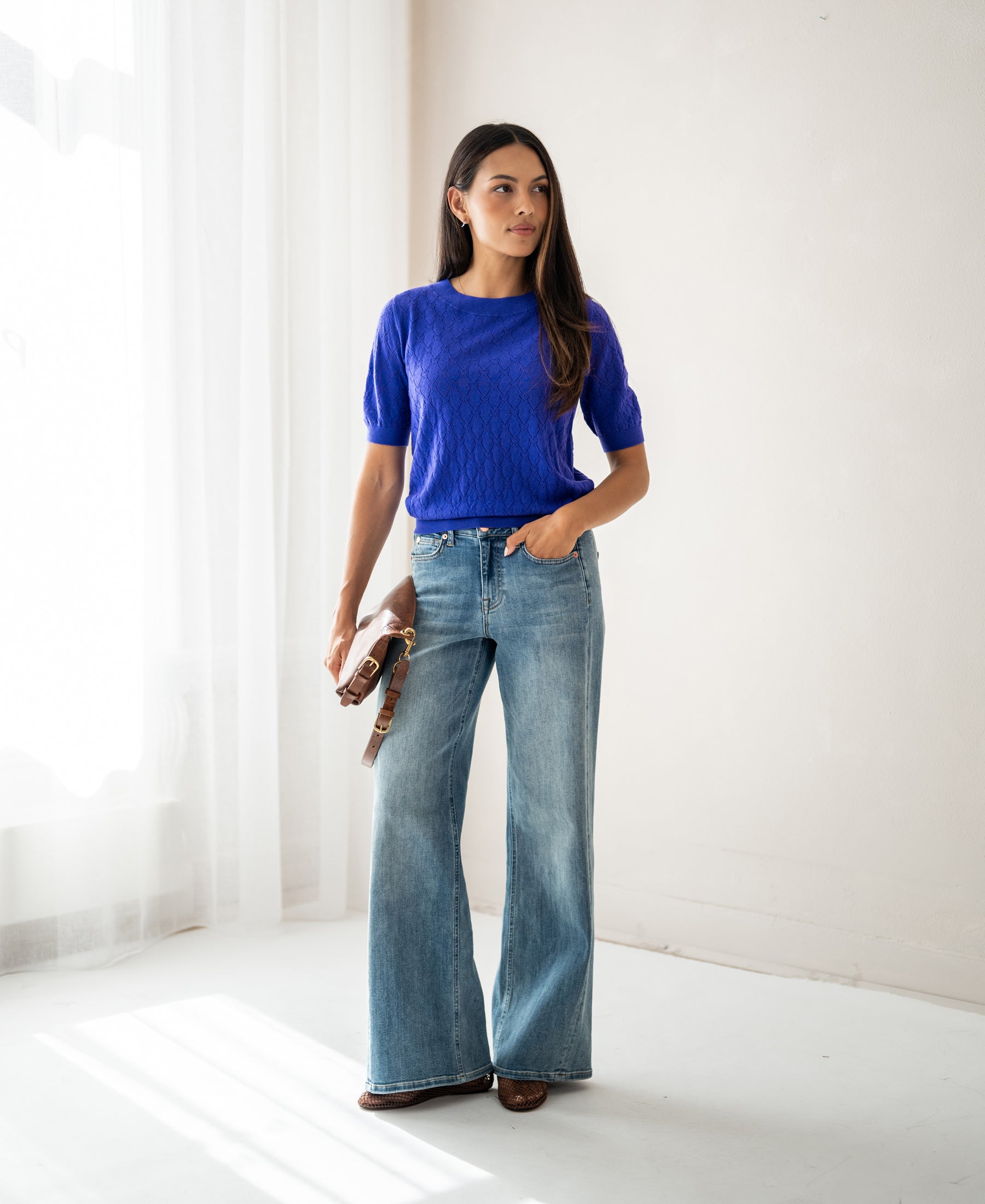 Woman wearing a PLEIN PUBLIQUE sweater with openwork pattern in Blue Iris.