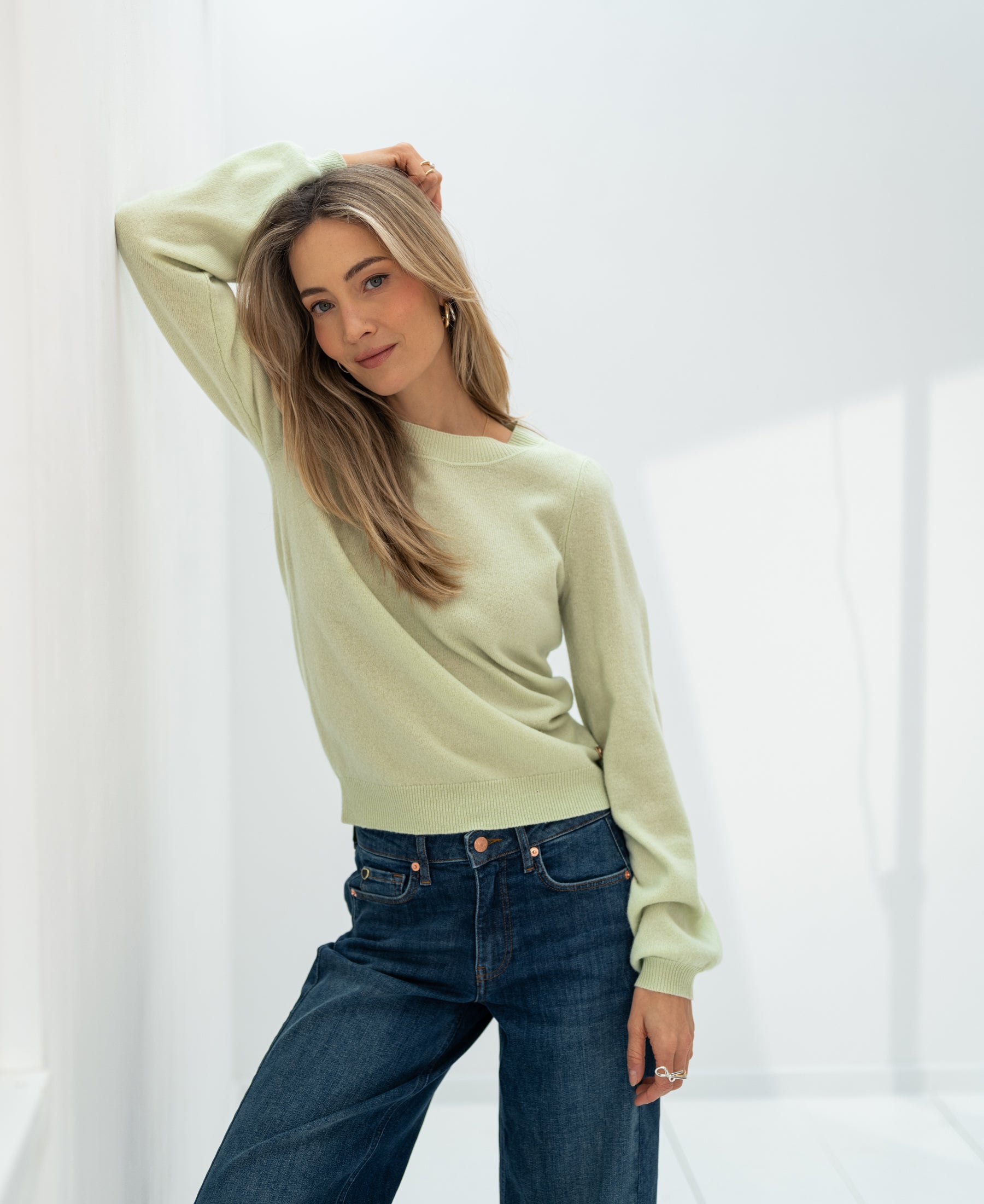 Soft light green merino wool sweater "LA BAYONNE" from PLEIN PUBLIQUE, shown worn against a white wall.