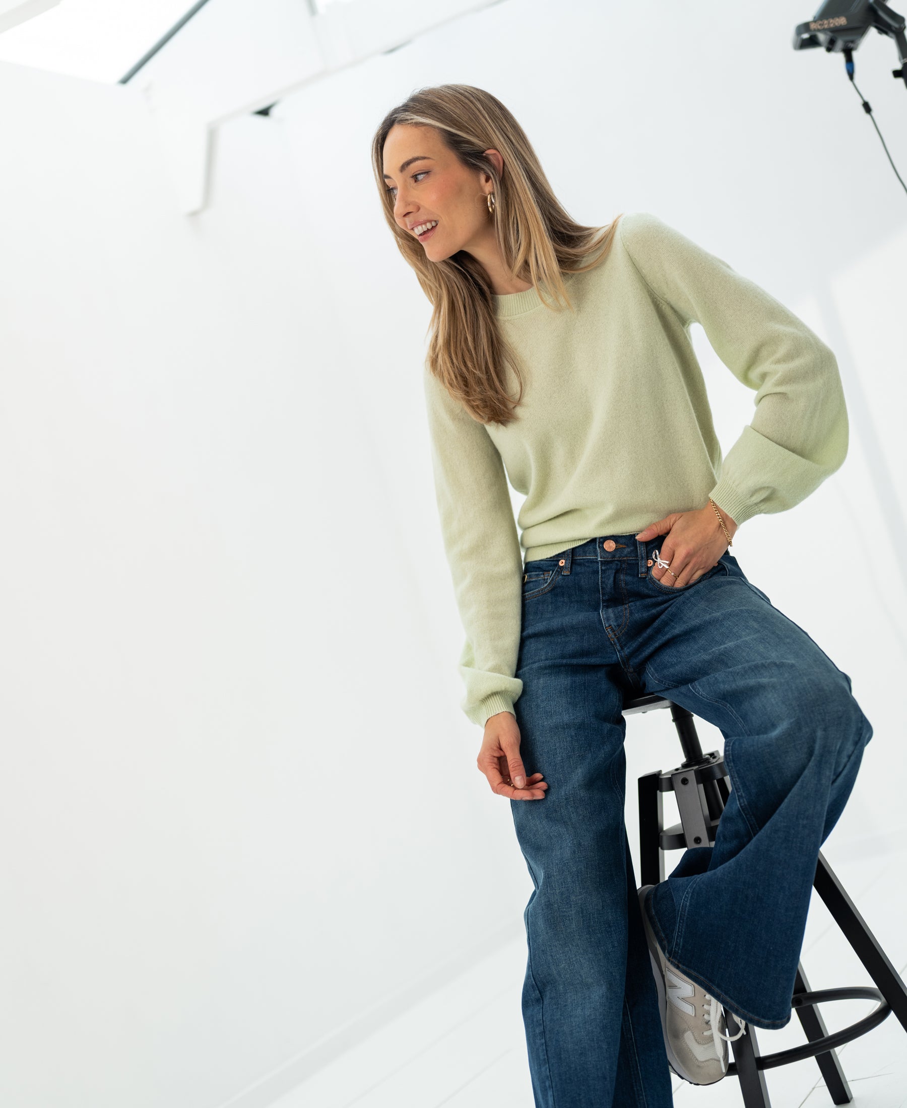 Light green soft merino wool sweater in a bright, minimalist studio.