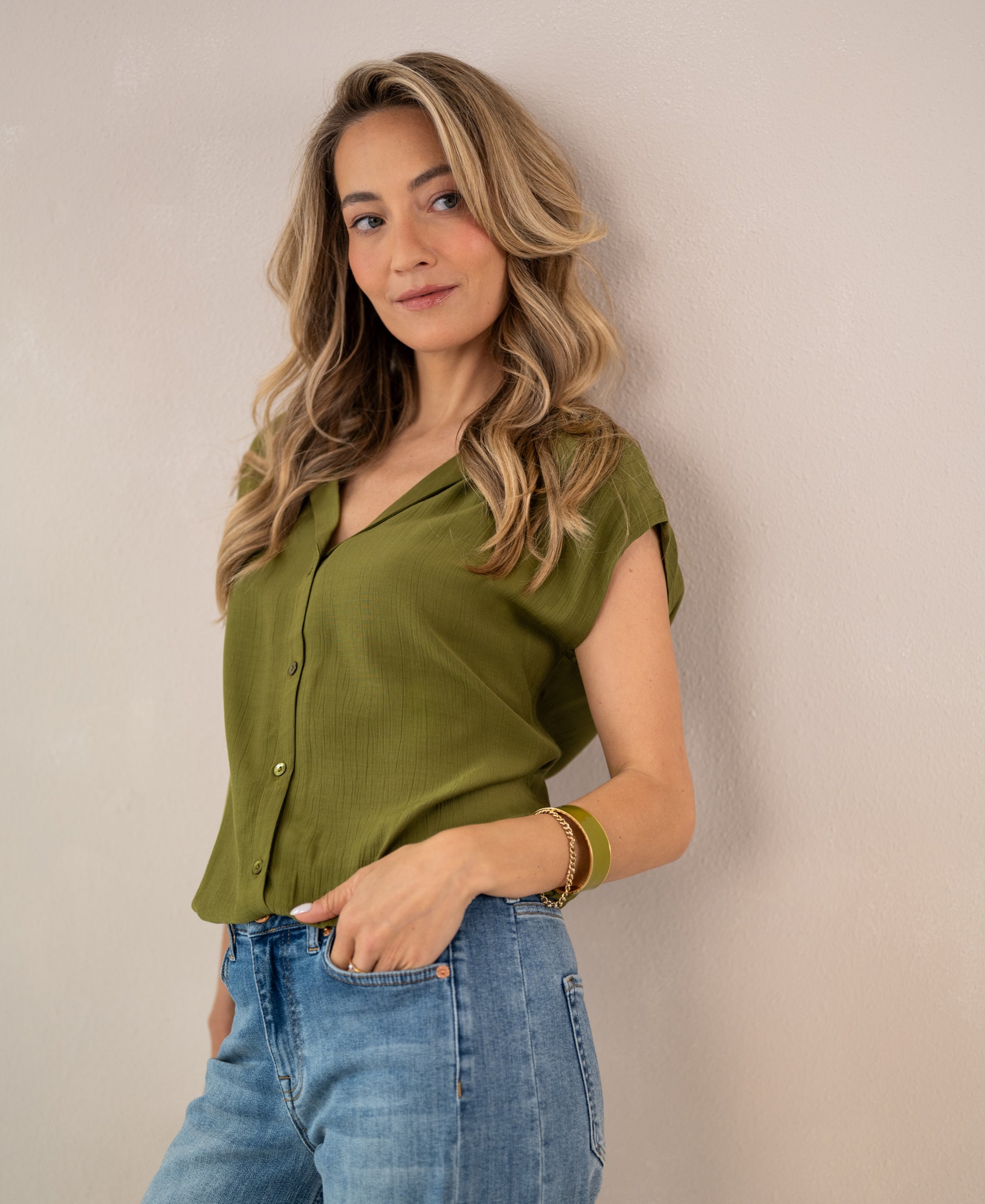 Sleeveless olive green blouse in lightweight fabric, shown from the front.