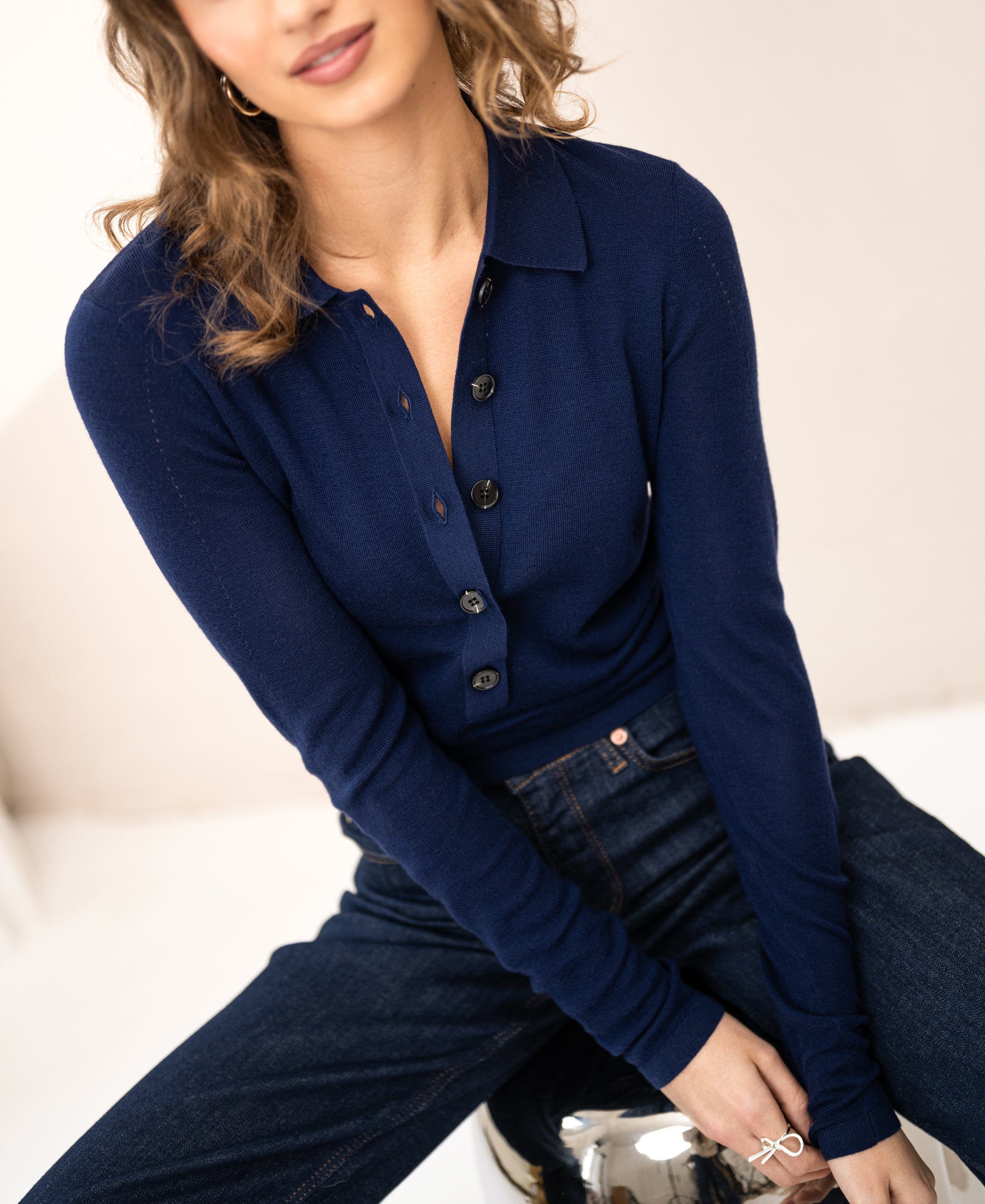 Woman wearing the Merino wool polo LE BOBIGNY in navy from PLEIN PUBLIQUE, soft smile.