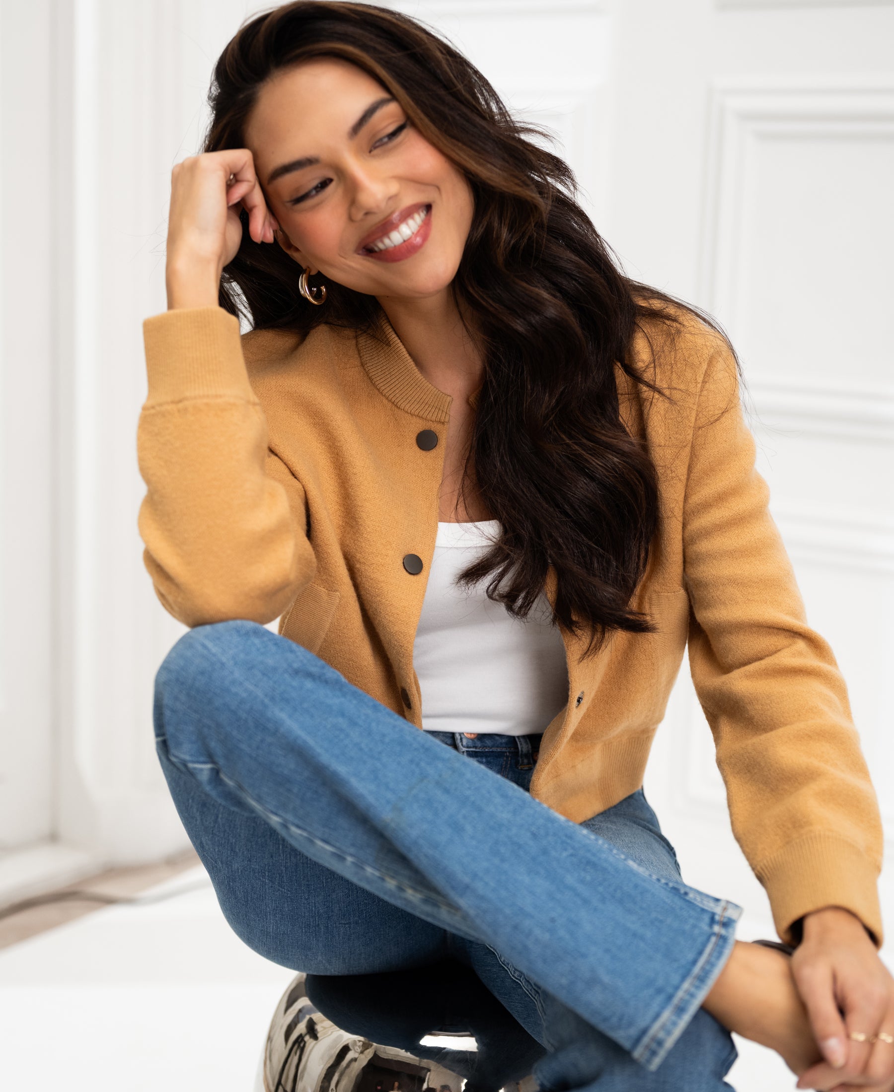 Light camel bomber jacket displayed indoors.