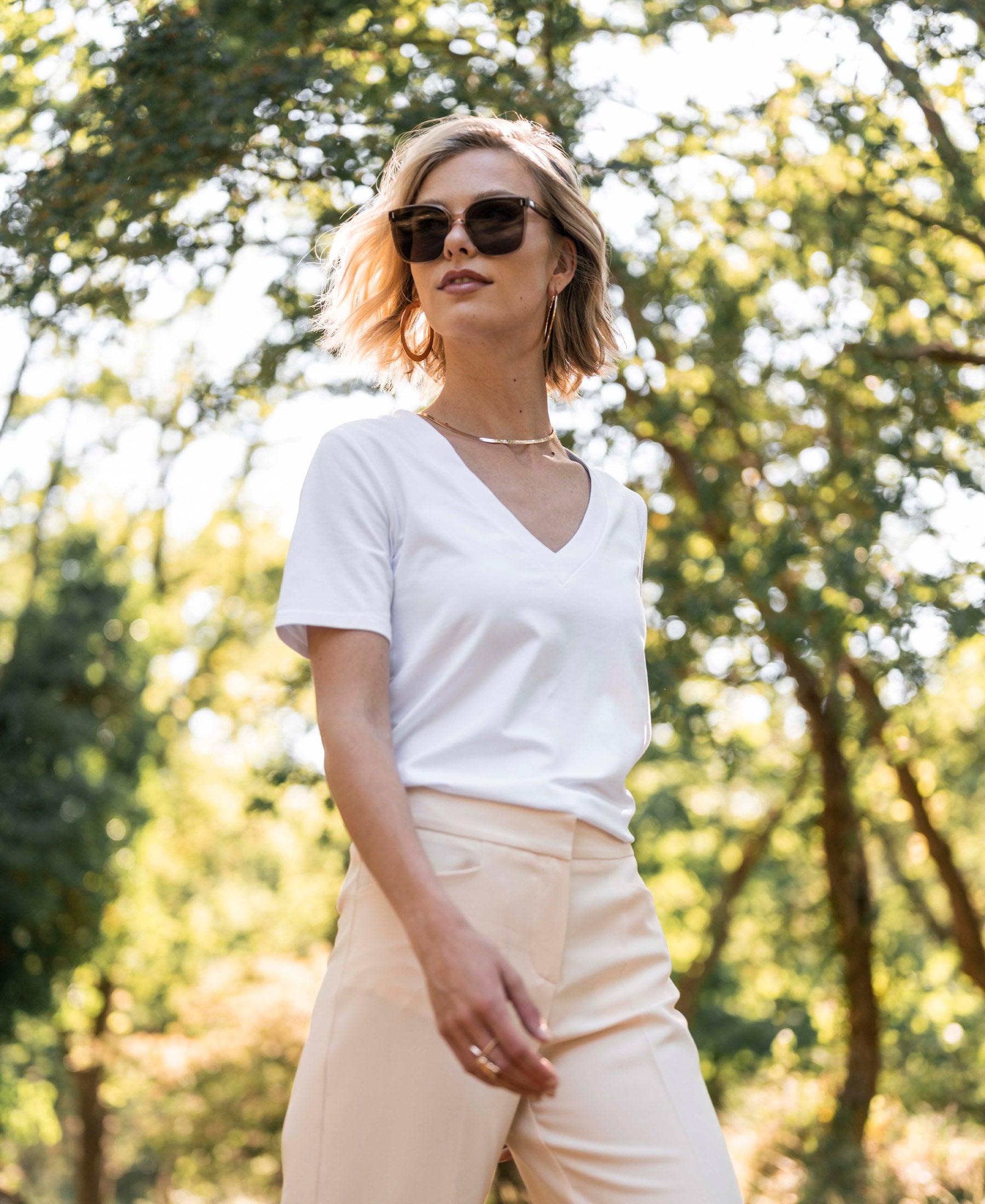 White PLEIN PUBLIQUE LA VIDA V-neck T-shirt shown outdoors with trees in the background.