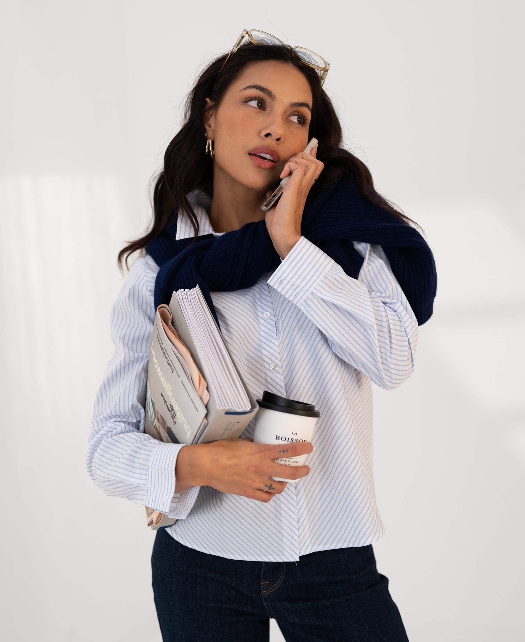 Woman wearing white and light blue striped blouse, front view.