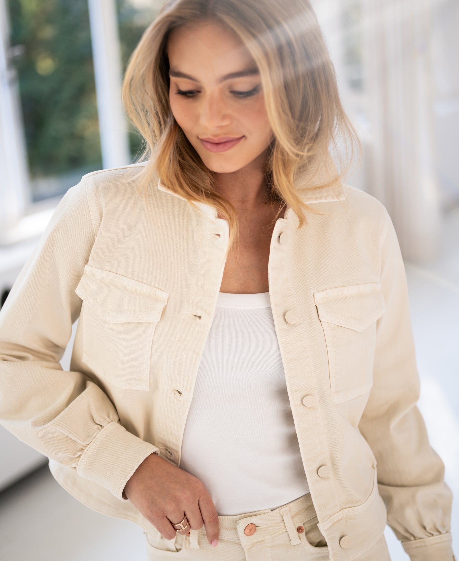 Cream stretch denim jacket shown indoors.