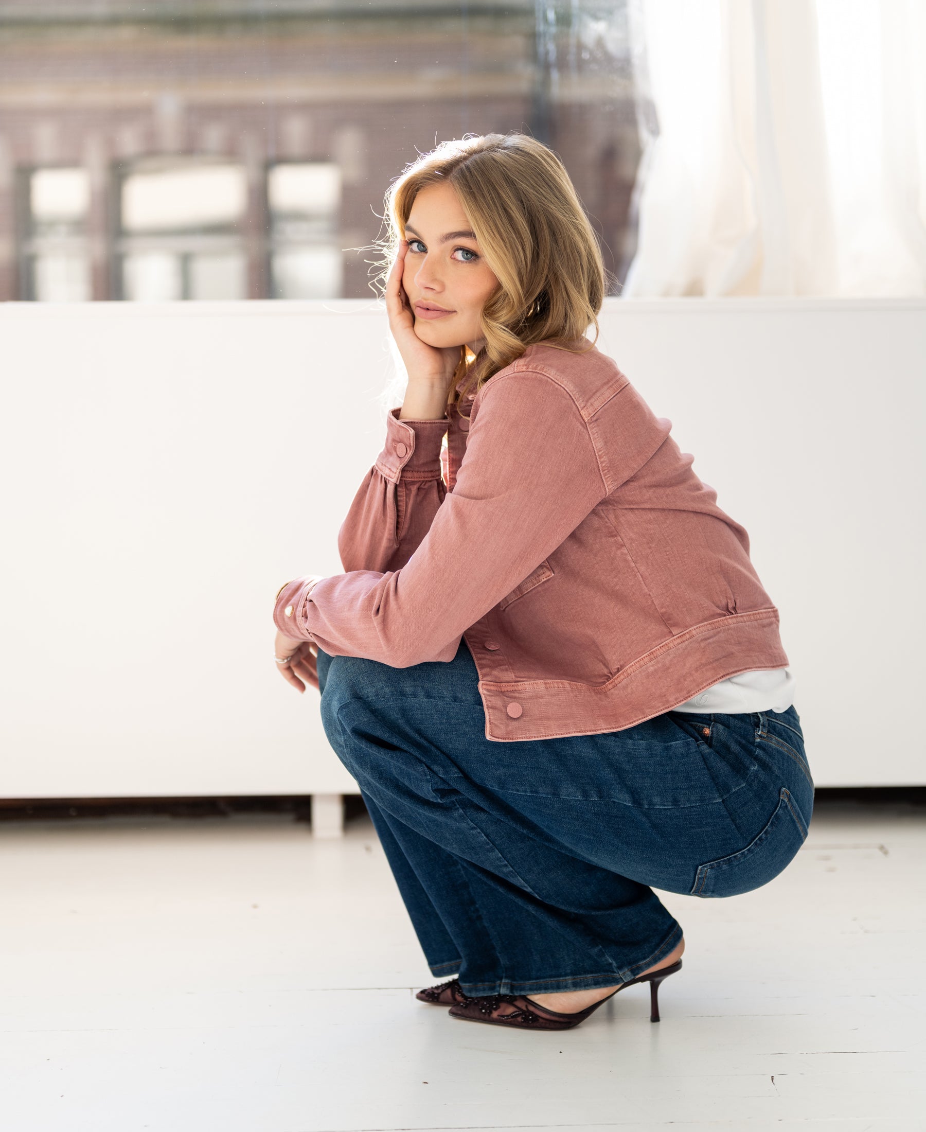 Stretch jean jacket in dusty pink, shown indoors.