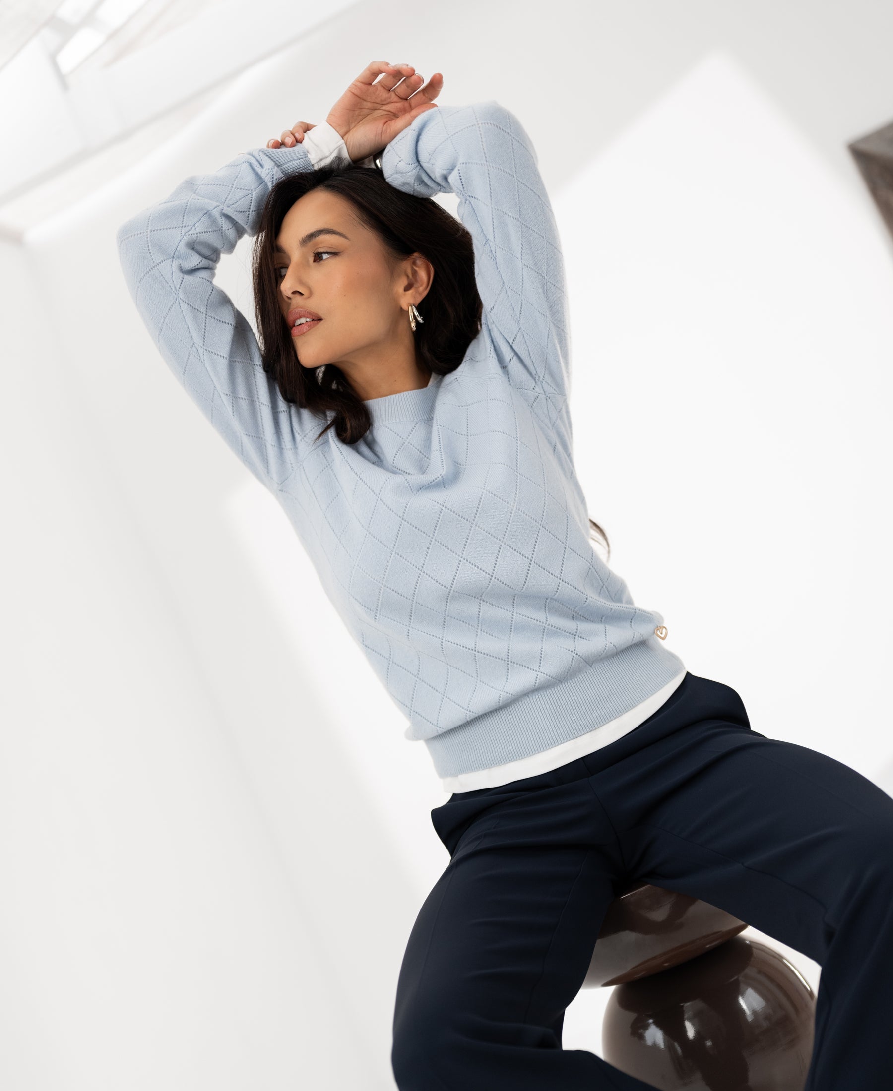 Light blue Argyle merino wool sweater LE CAMBRIDGE by PLEIN PUBLIQUE displayed in a bright, modern room.