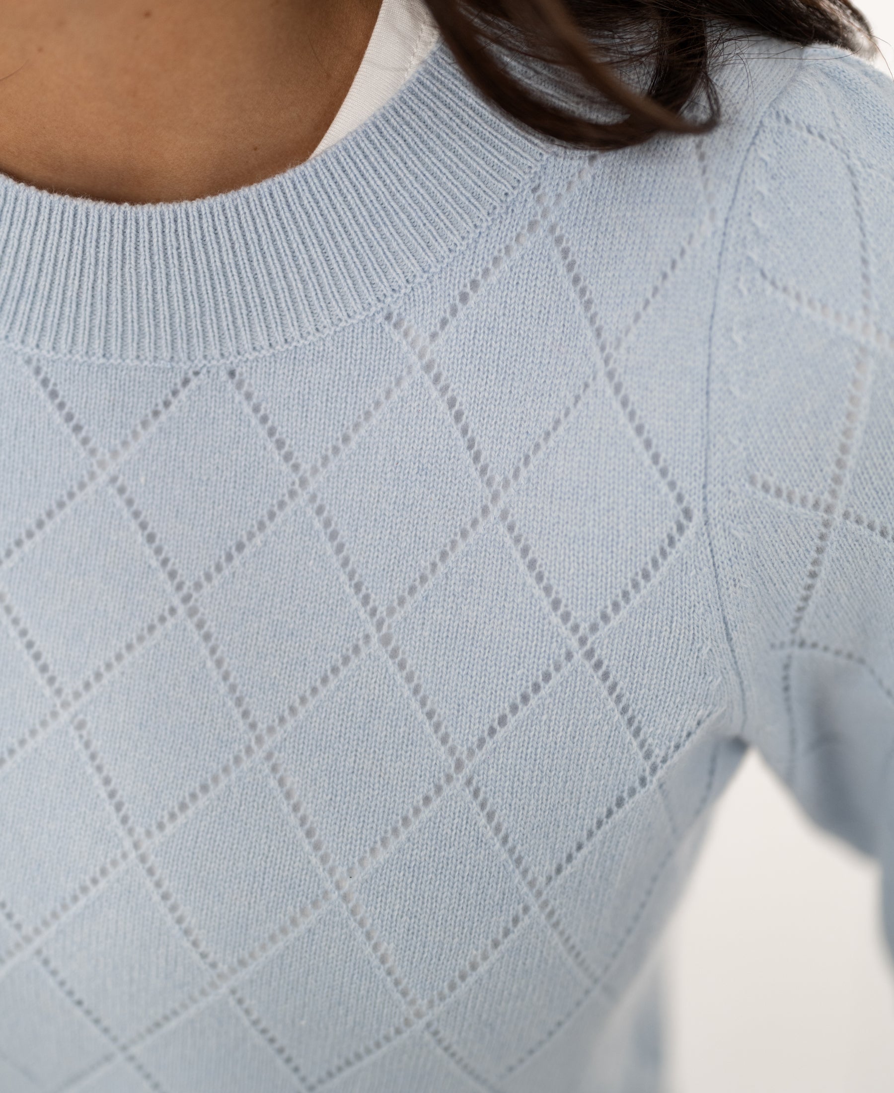Close-up of the LE CAMBRIDGE Argyle light blue merino sweater by PLEIN PUBLIQUE, showing neckline and shoulder.