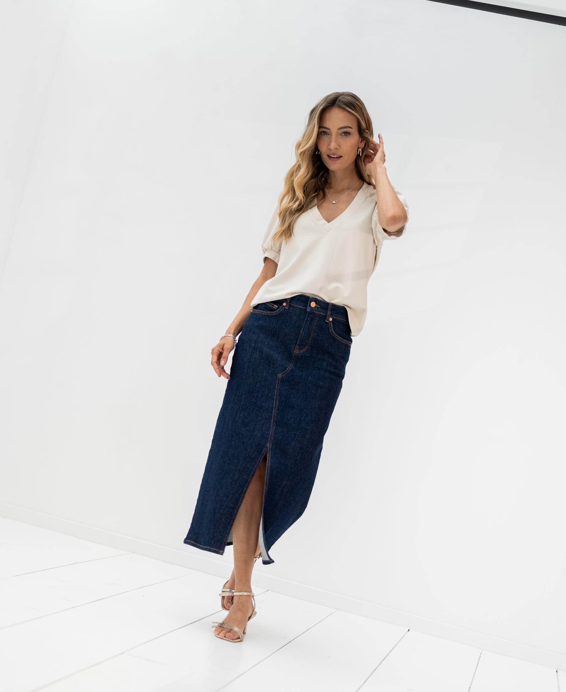 Denim skirt LA JUNE in rinse wash by PLEIN PUBLIQUE, shown in a bright, minimal white room.