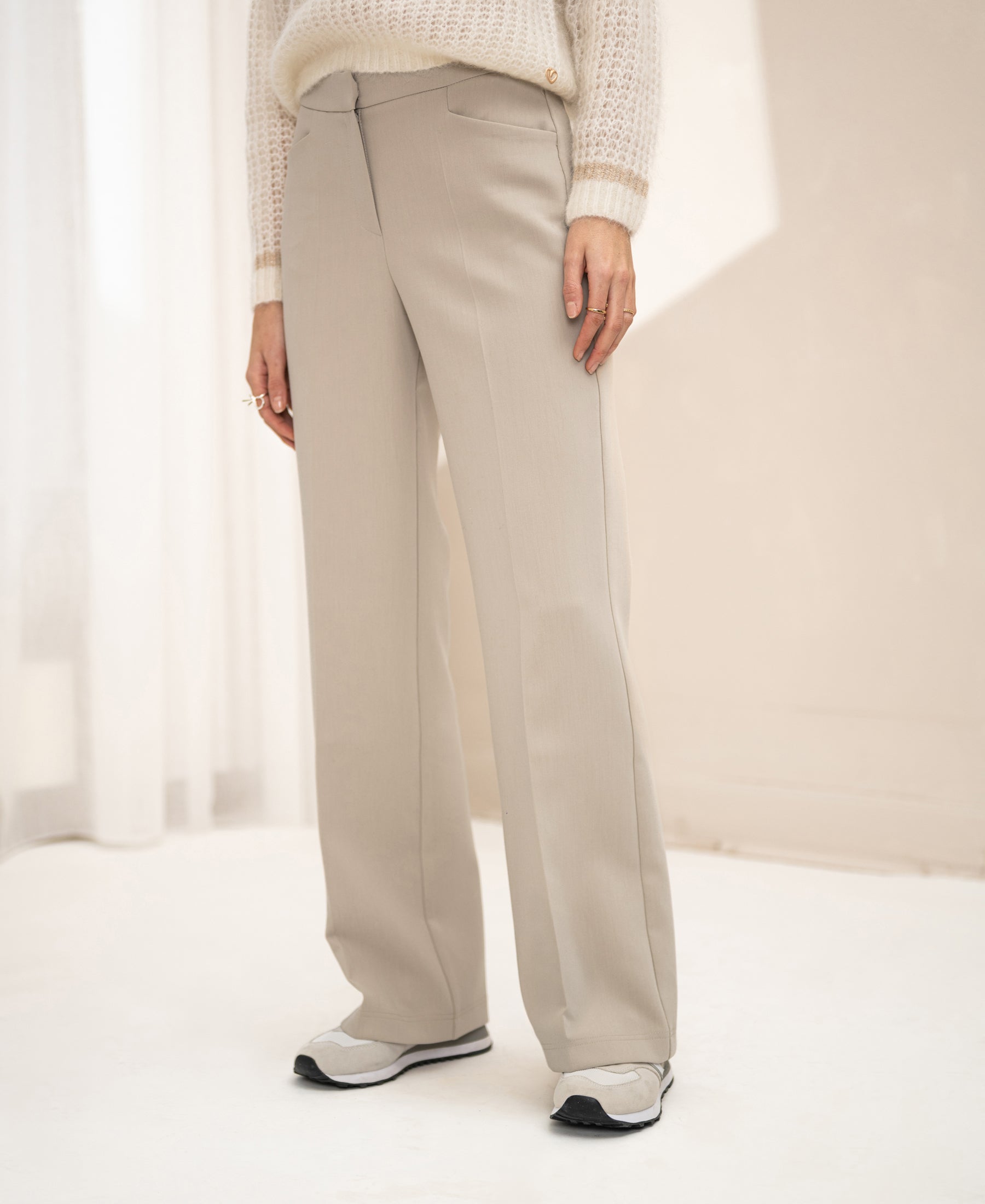 Woman wearing PLEIN PUBLIQUE wide-leg trousers LE CENTRE Kitt, standing indoors on a light floor.