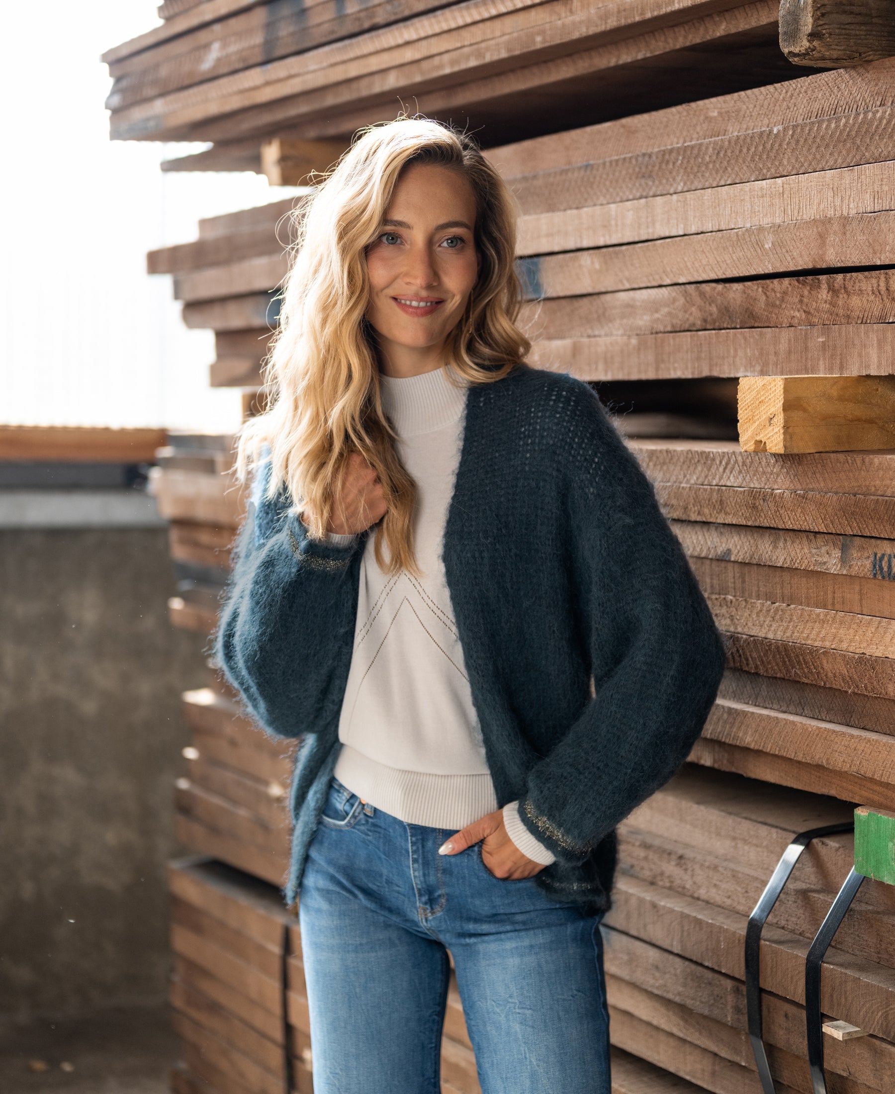 Woman wearing the PLEIN PUBLIQUE fluffy vest LA CHERIE in dark mist green, smiling at the camera.