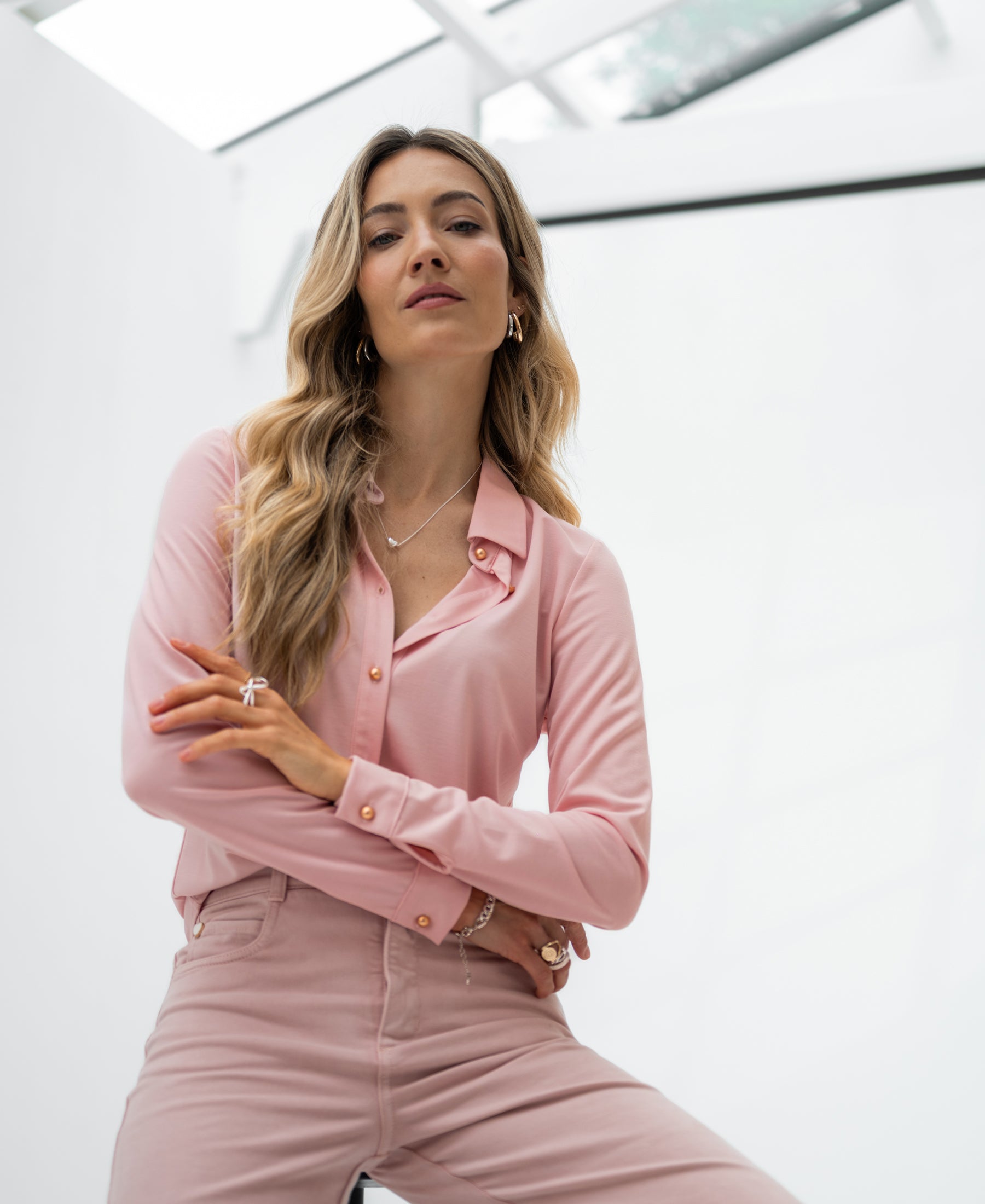 Light pink PLEIN PUBLIQUE travel blouse LA CHERISE shown on a woman indoors.