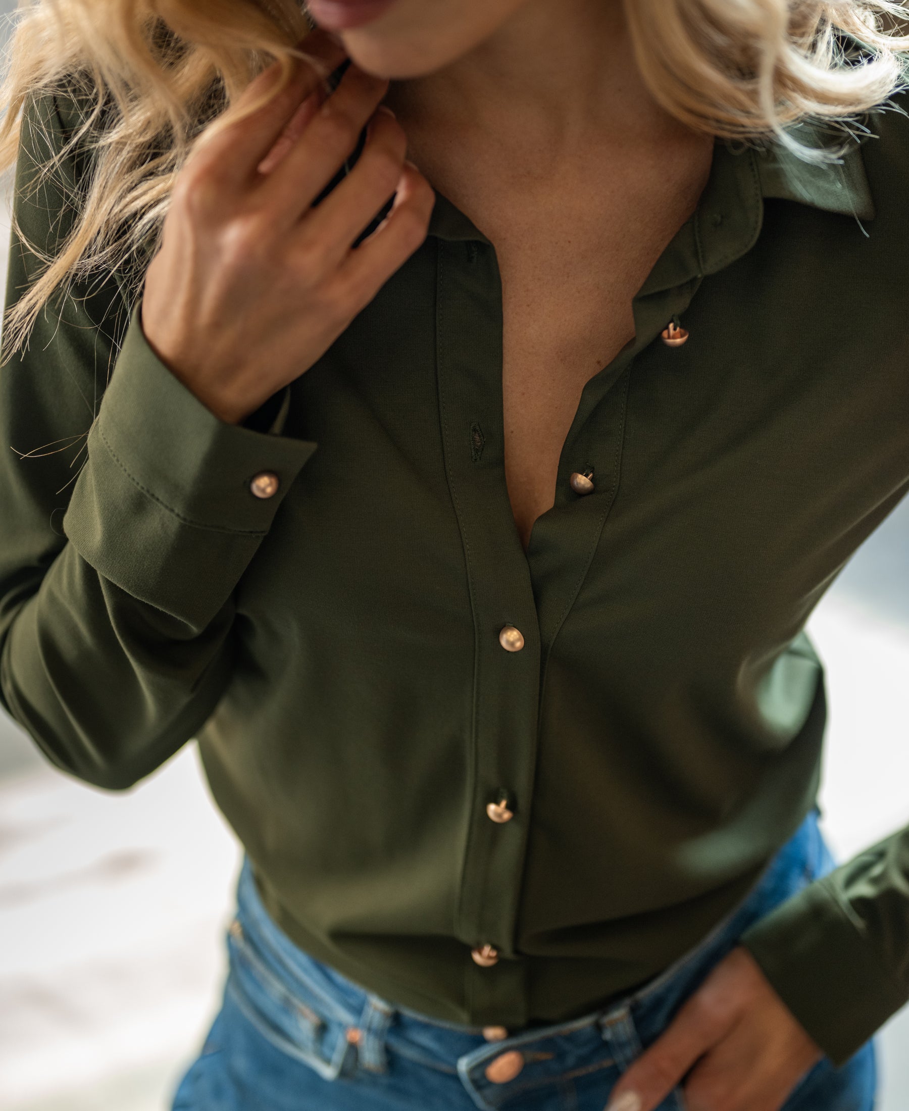 Front view of a woman wearing the PLEIN PUBLIQUE army green travel blouse called The Cherry.