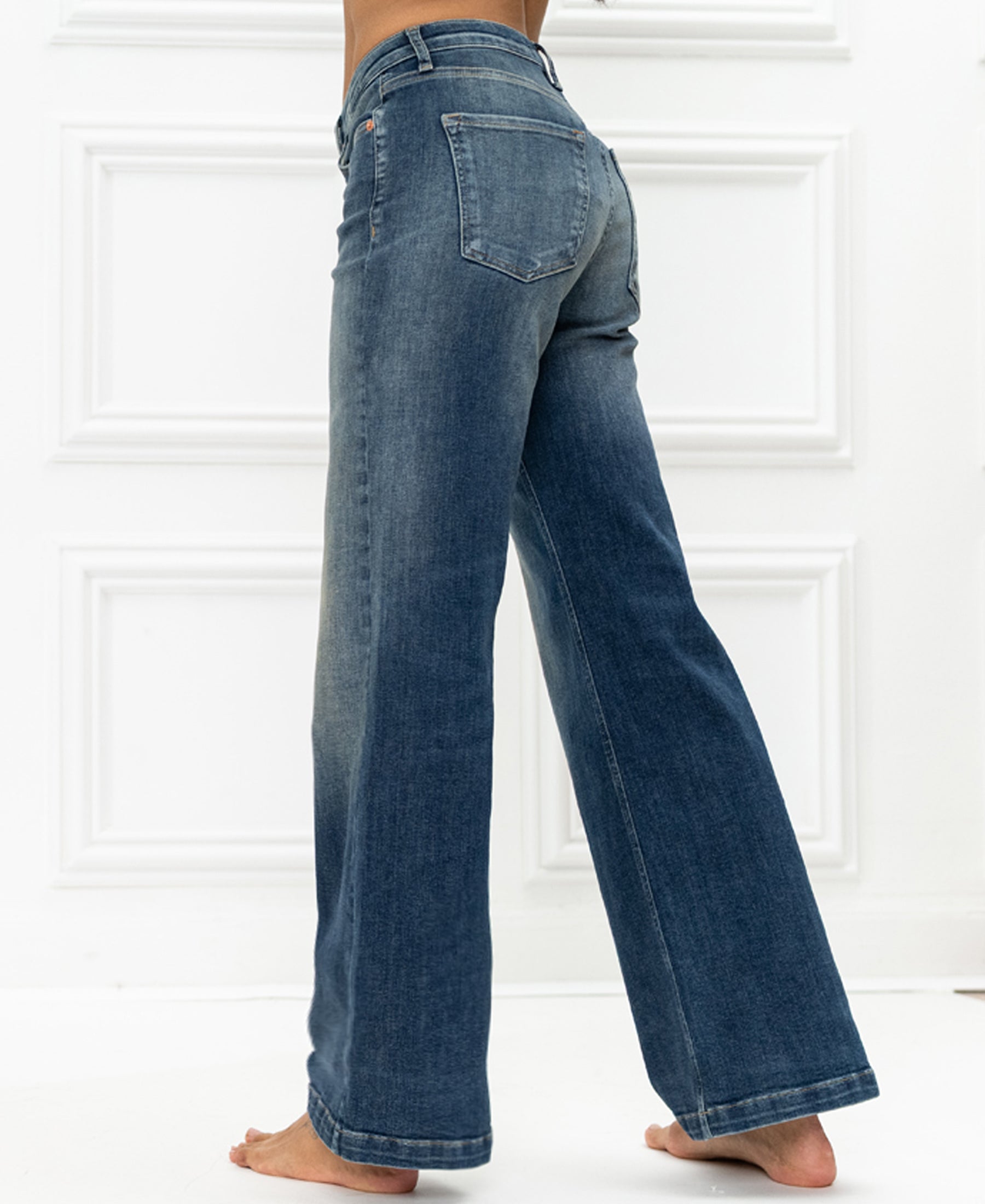 Wide leg blue vintage jeans by Plein Publique against a white background.