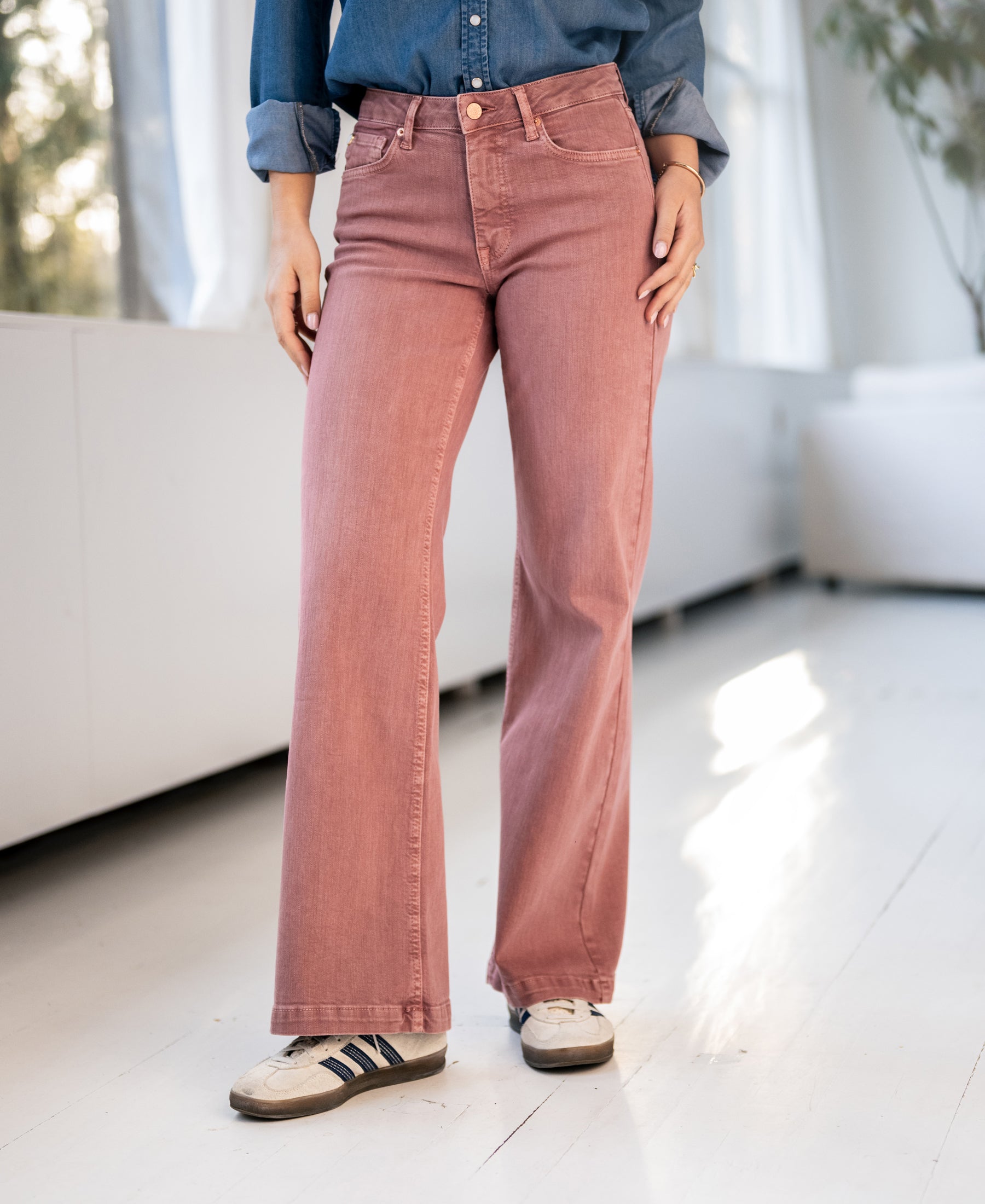 Dusty pink PLEIN PUBLIQUE jeans shown indoors on a white floor.