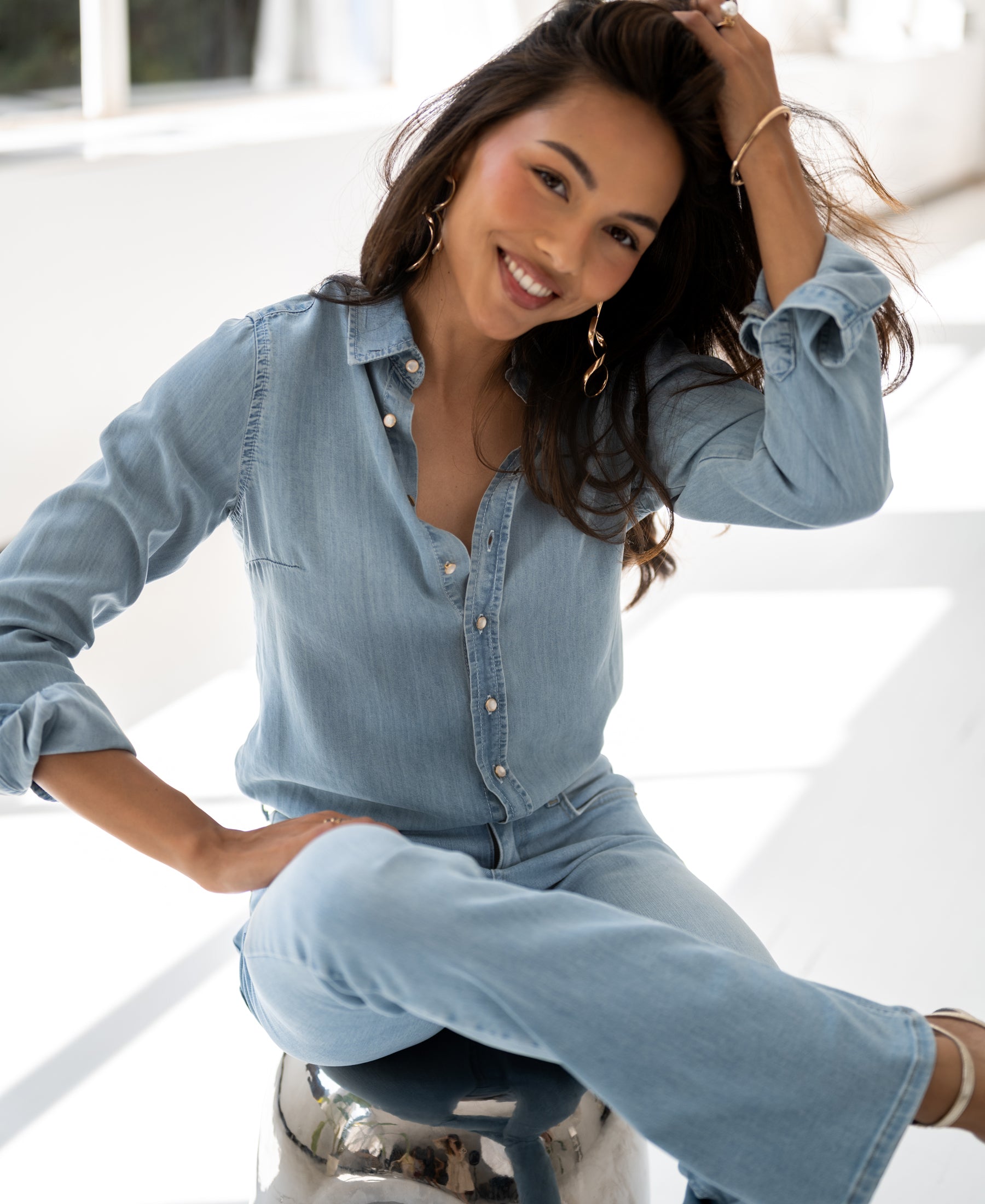 Tencel denim blouse in bleached wash by PLEIN PUBLIQUE displayed in a bright room.