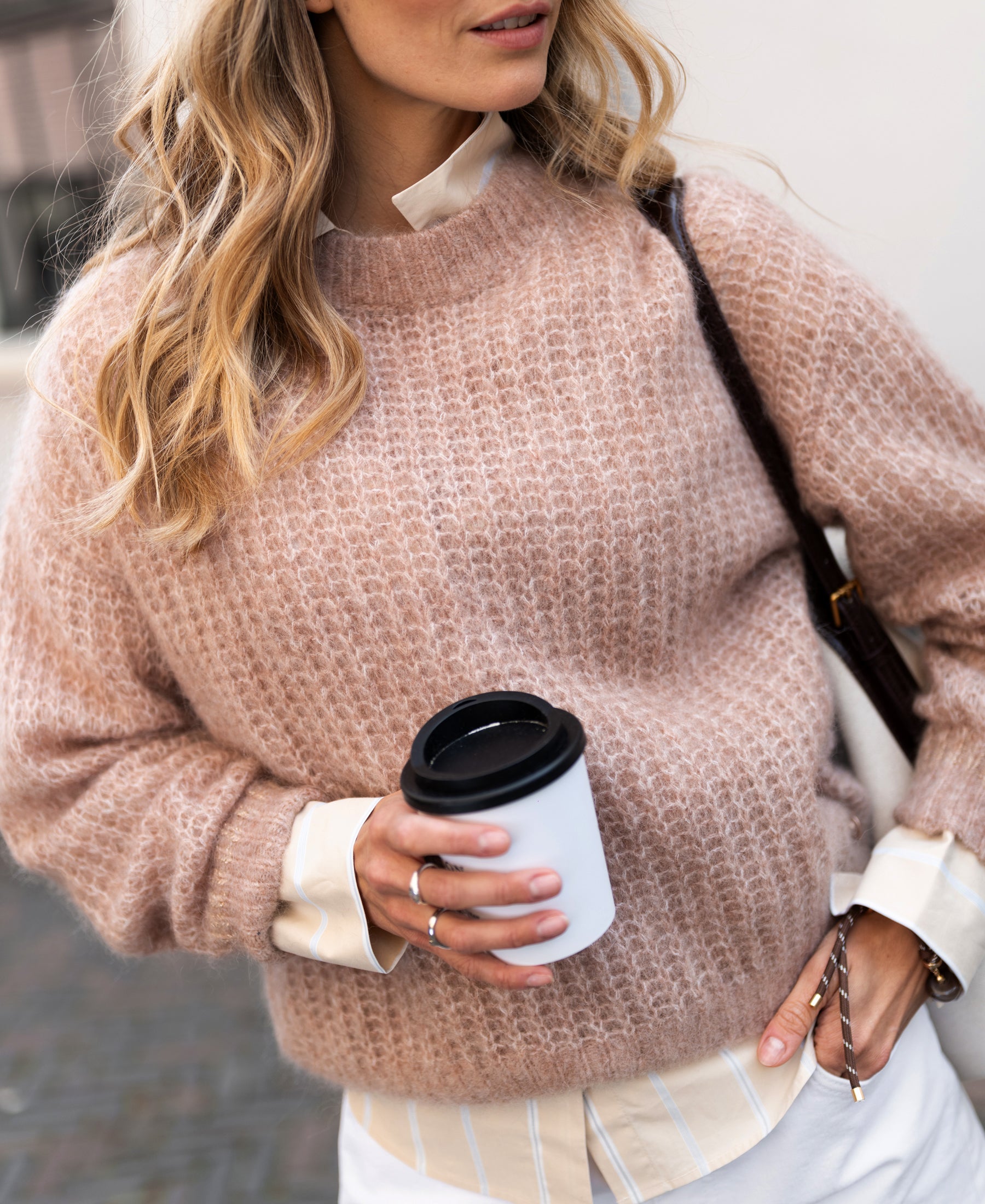 Woman with wavy blonde hair wears PLEIN PUBLIQUE’s Mohair sweater LA DOUCE in Fudge brown.