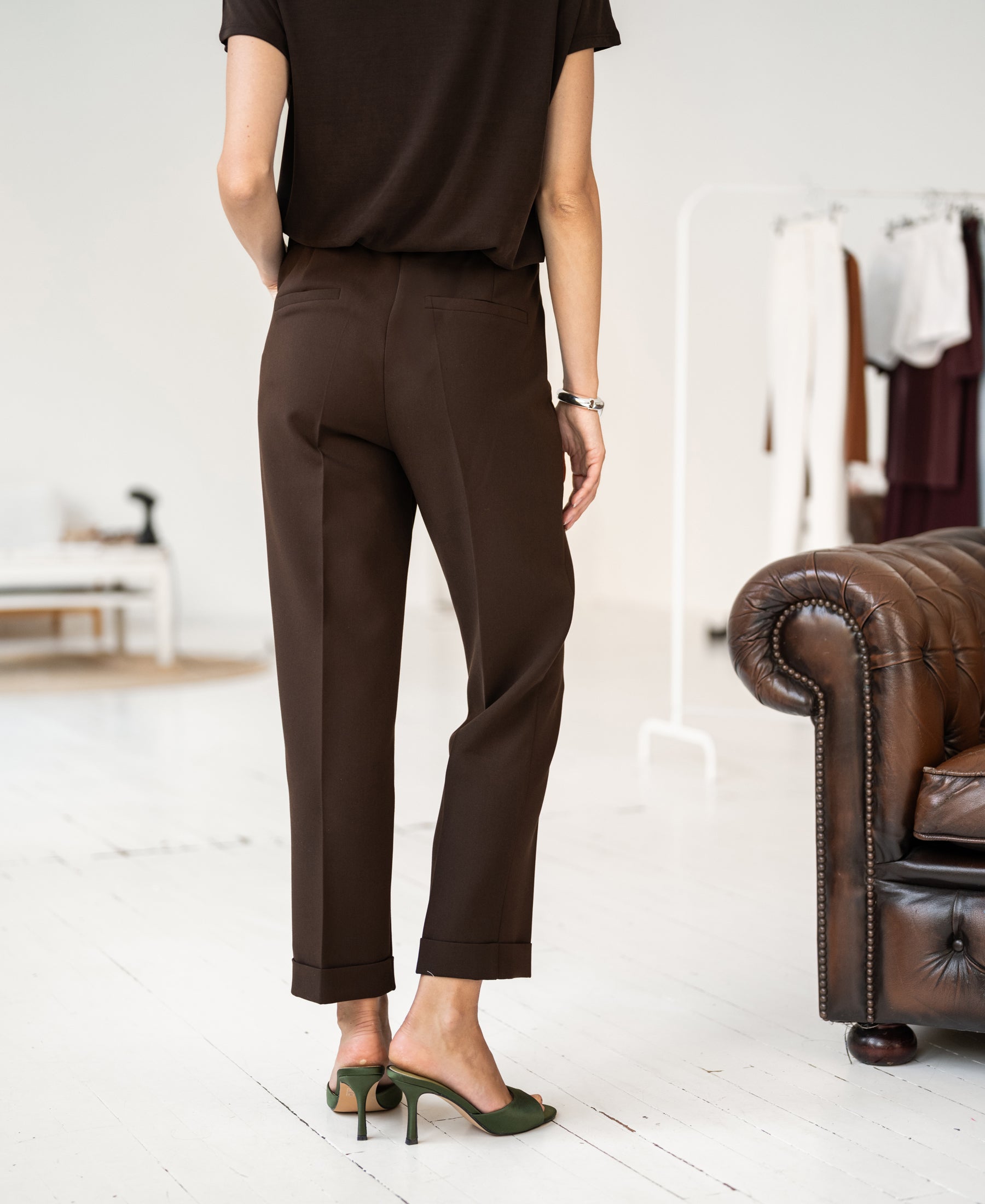 Person wearing PLEIN PUBLIQUE 7/8 LE FAUBOURG pants in pure chocolate color.