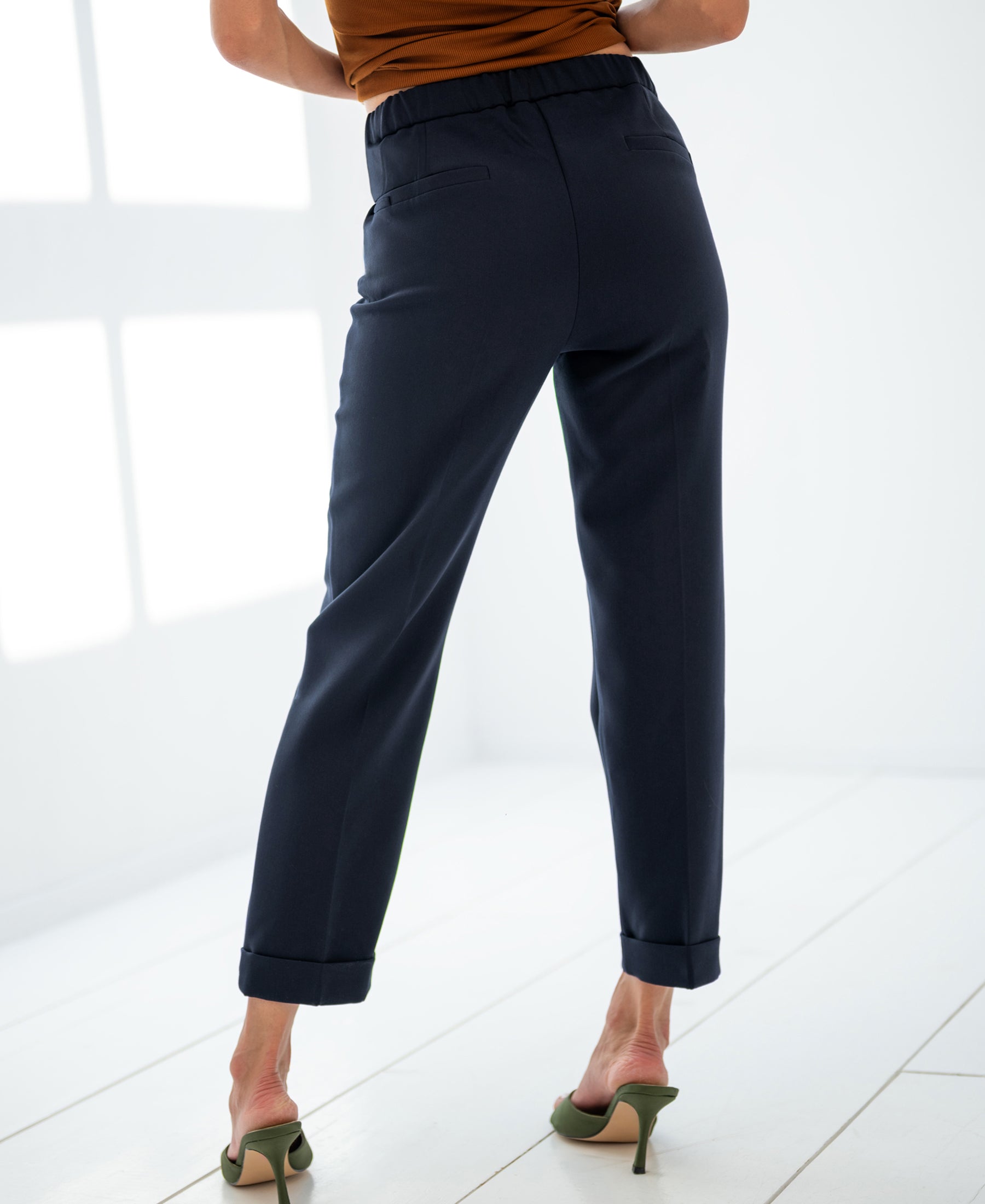 Person wearing dark blue PLEIN PUBLIQUE 7/8 LE FAUBOURG trousers stands on a white floor.