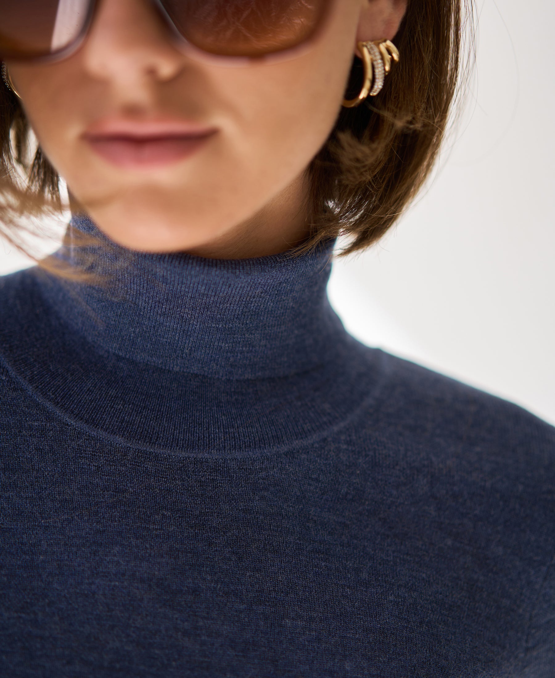 Short-sleeve turtleneck sweater in blue from lips to chest visible.