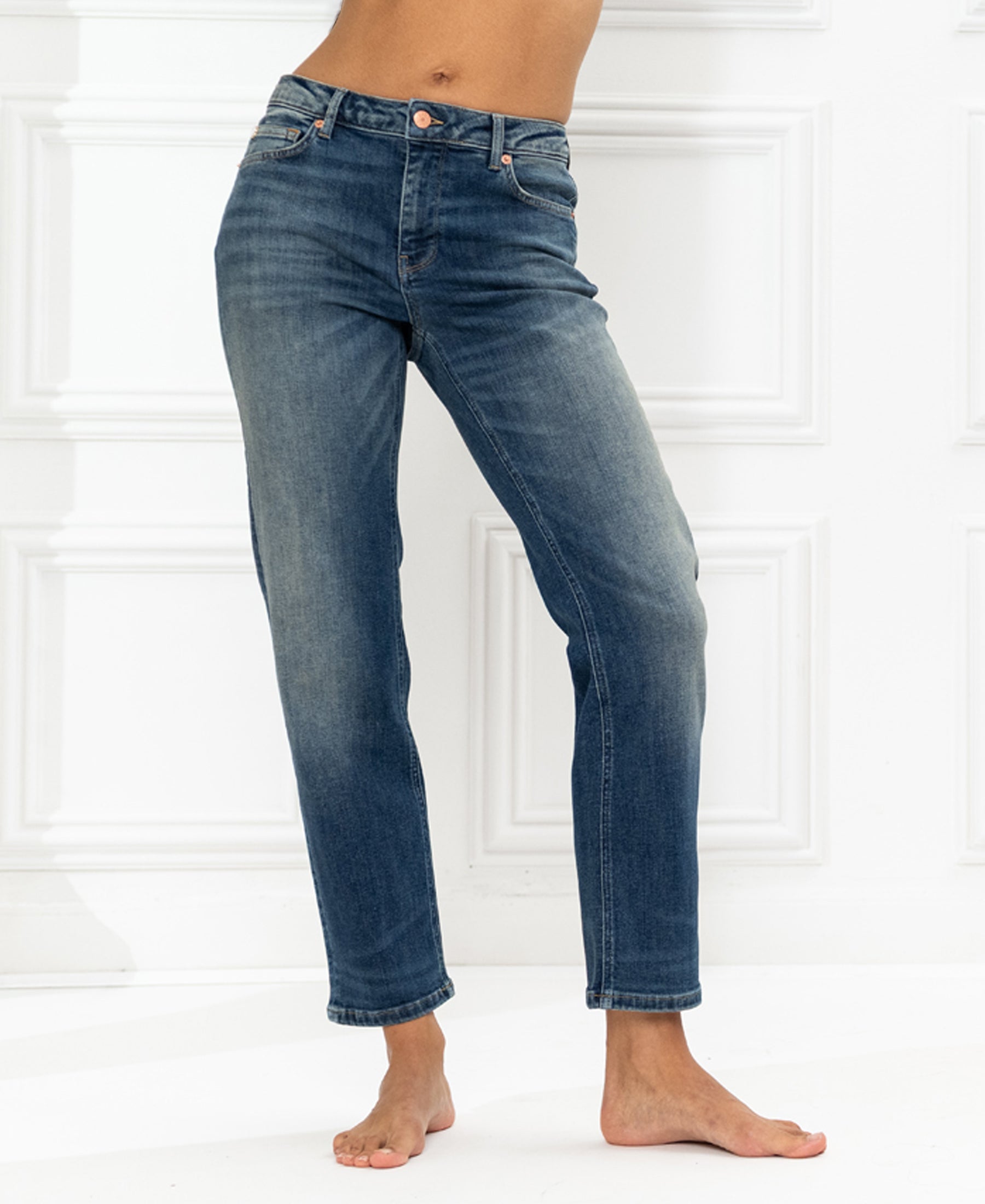 Cropped jeans in blue vintage wash, LE GUY style, shown against a white textured wall.