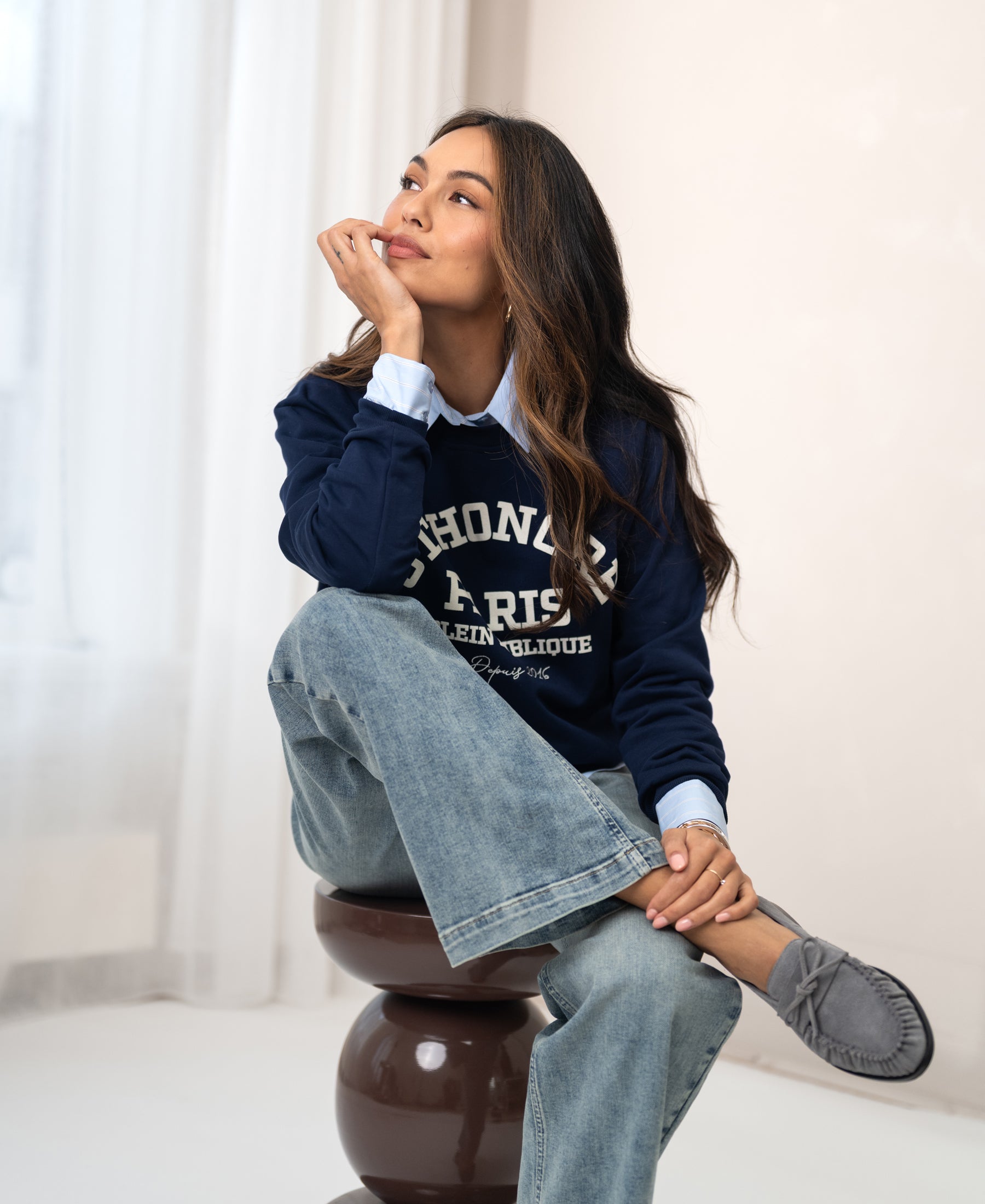 A woman wears a Plein Publique La Harper dark blue sweater.
