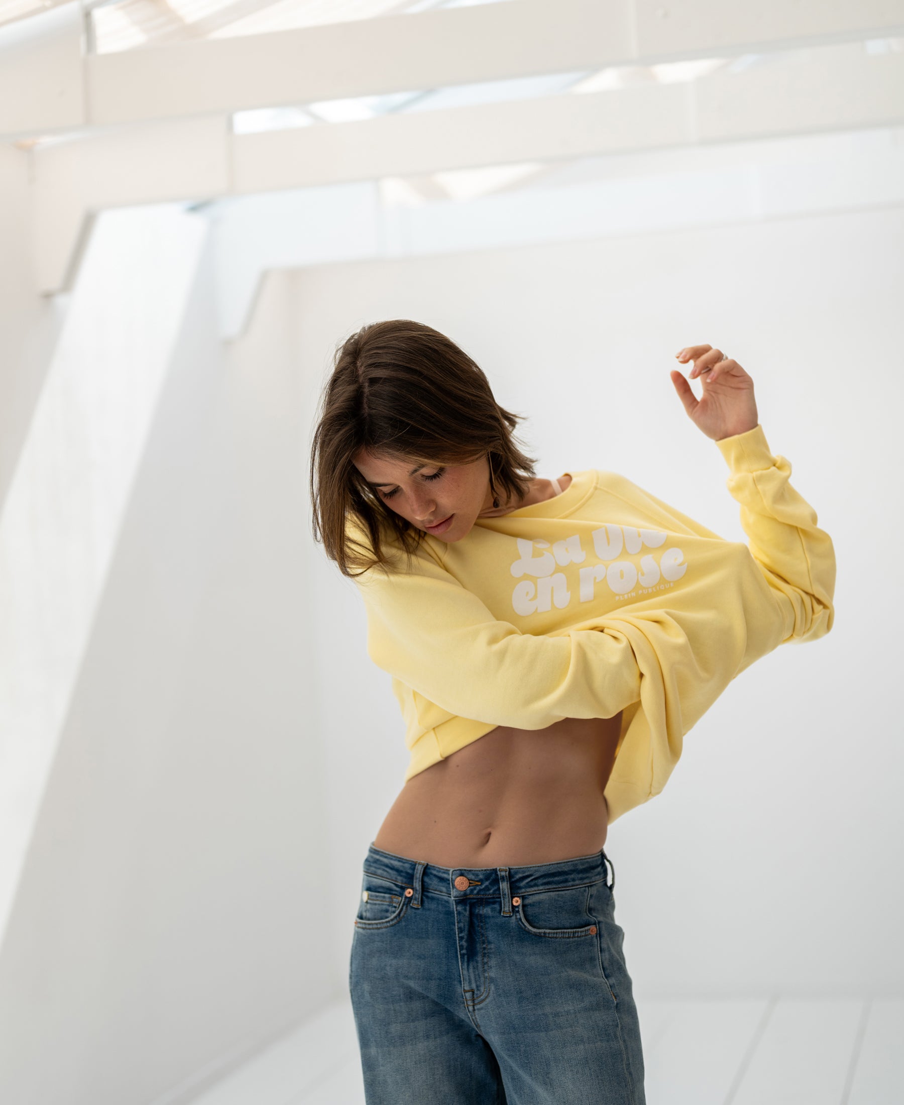 Yellow LA HARPER sweater by PLEIN PUBLIQUE shown in a bright white room.