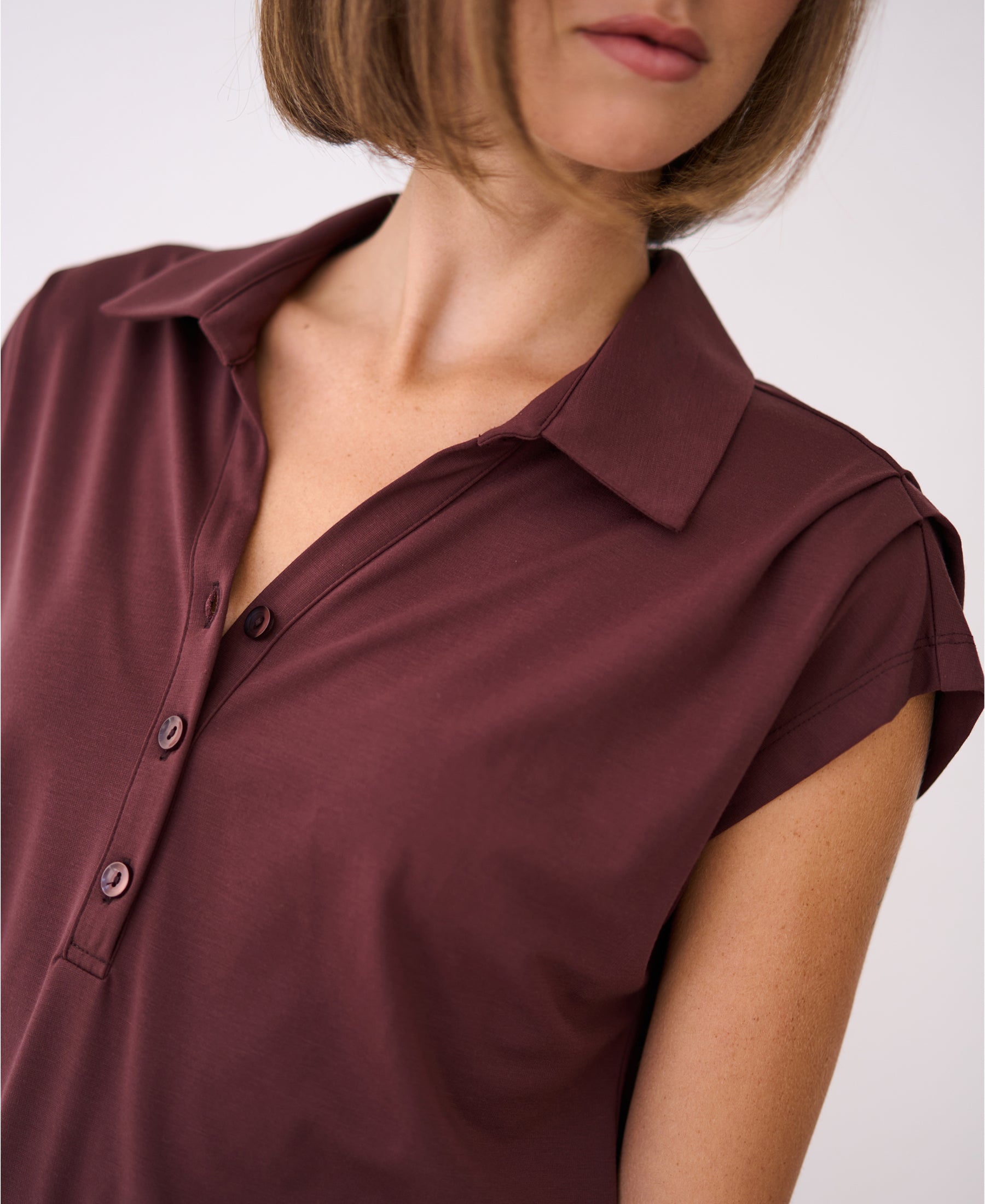 Brown short-sleeve travel polo dress, shown from shoulders up against a plain background.