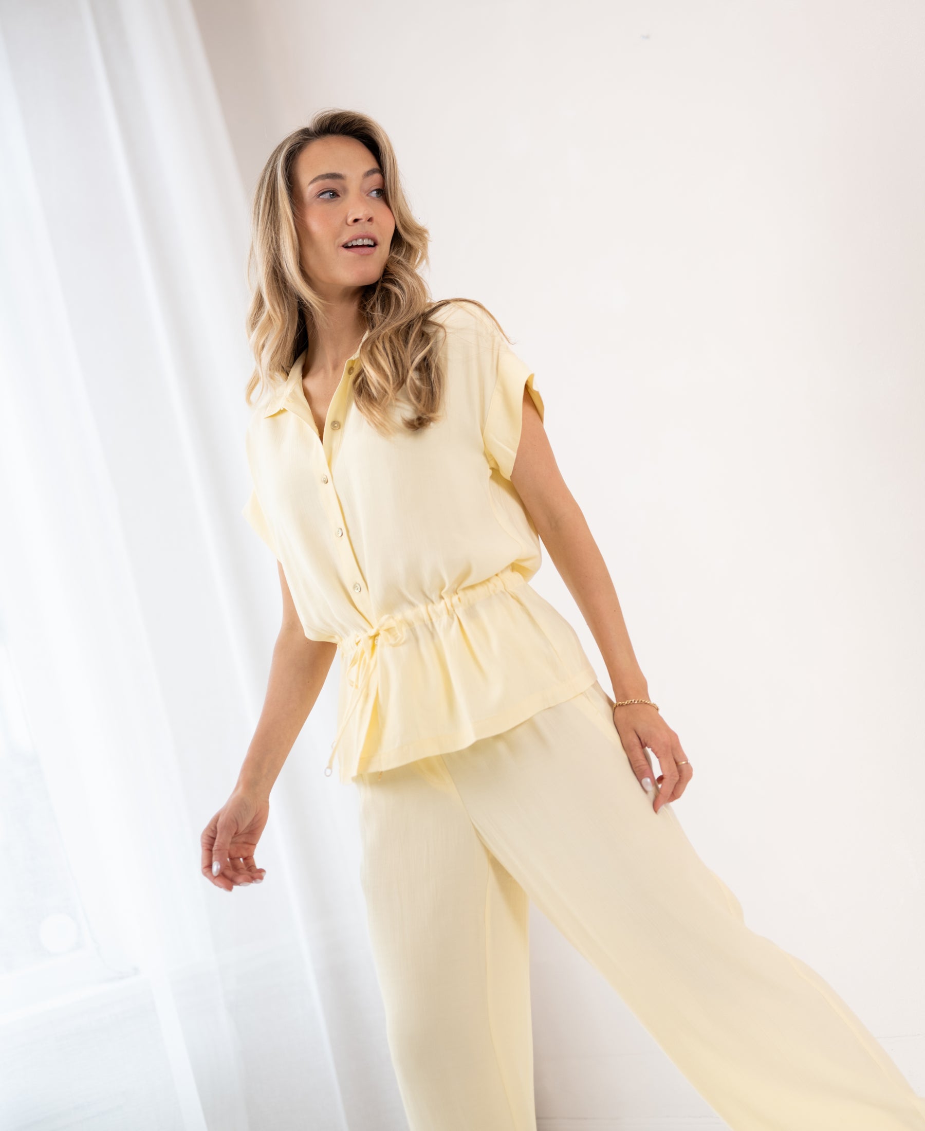 Light yellow LA JODY blouse by PLEIN PUBLIQUE, shown from the side.