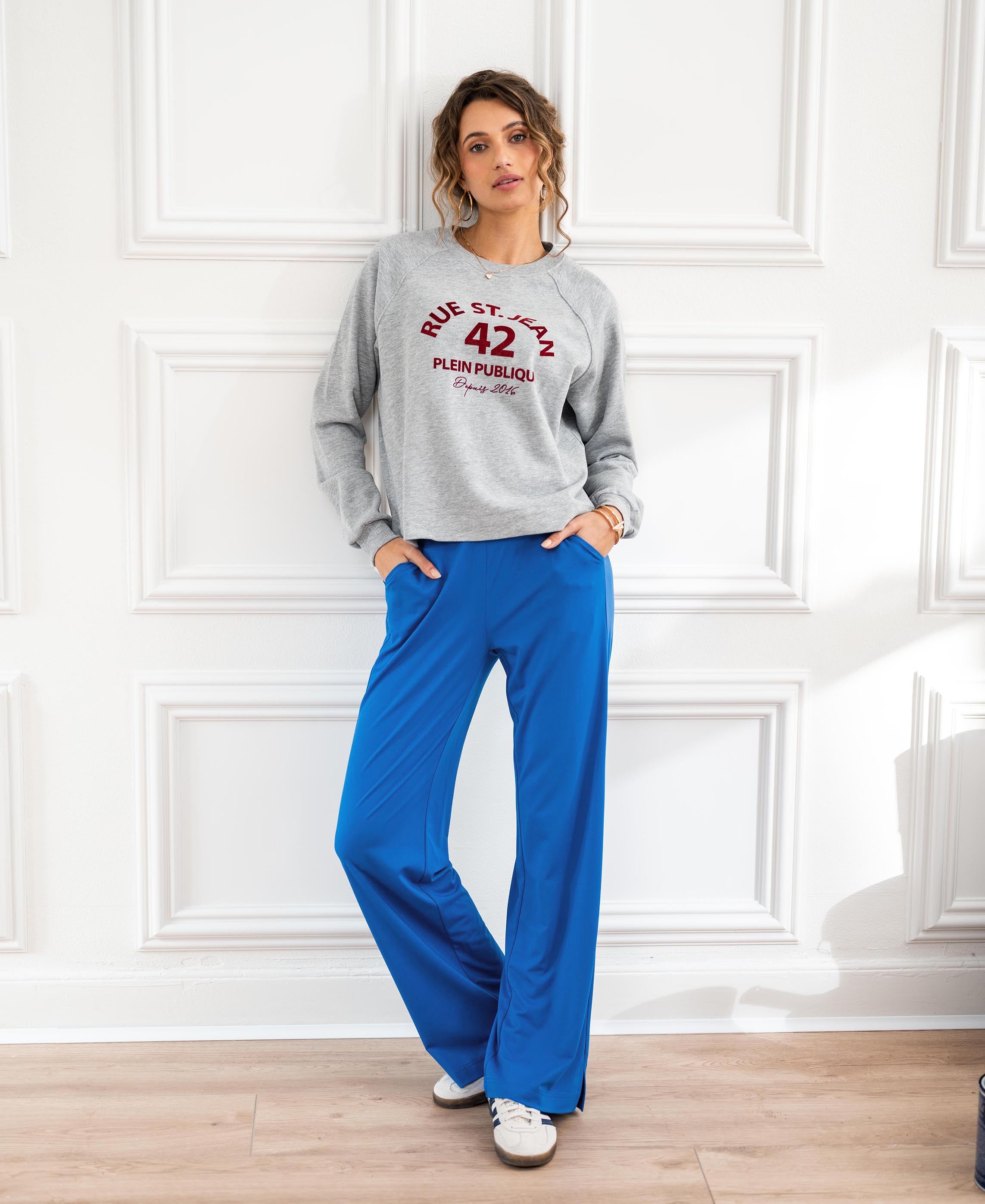 Blue LES JULES travel pants on sale, shown from the front against a white wall.