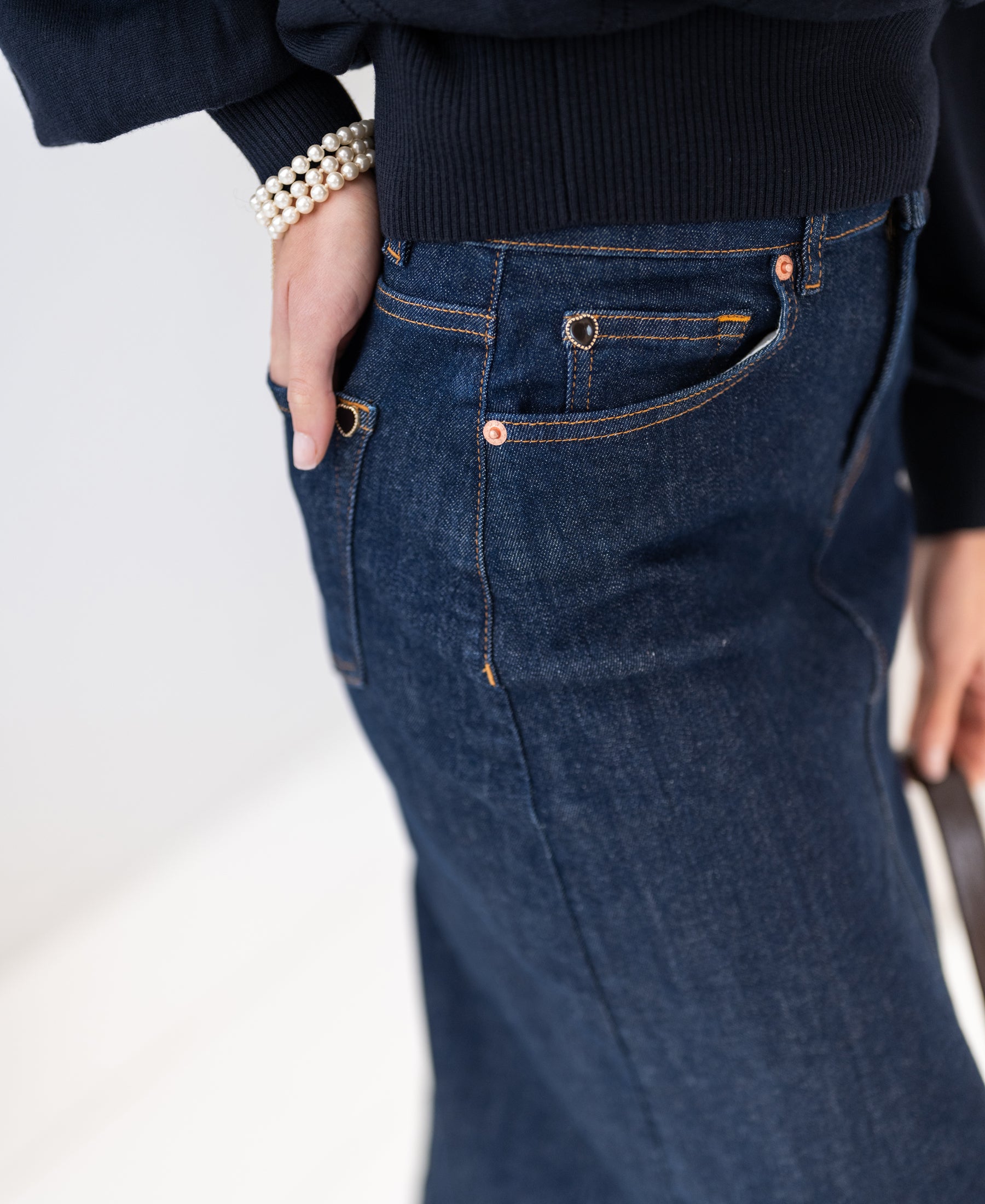 Close-up of the SALE LA JUNE rinse wash denim skirt, one hand in pocket.