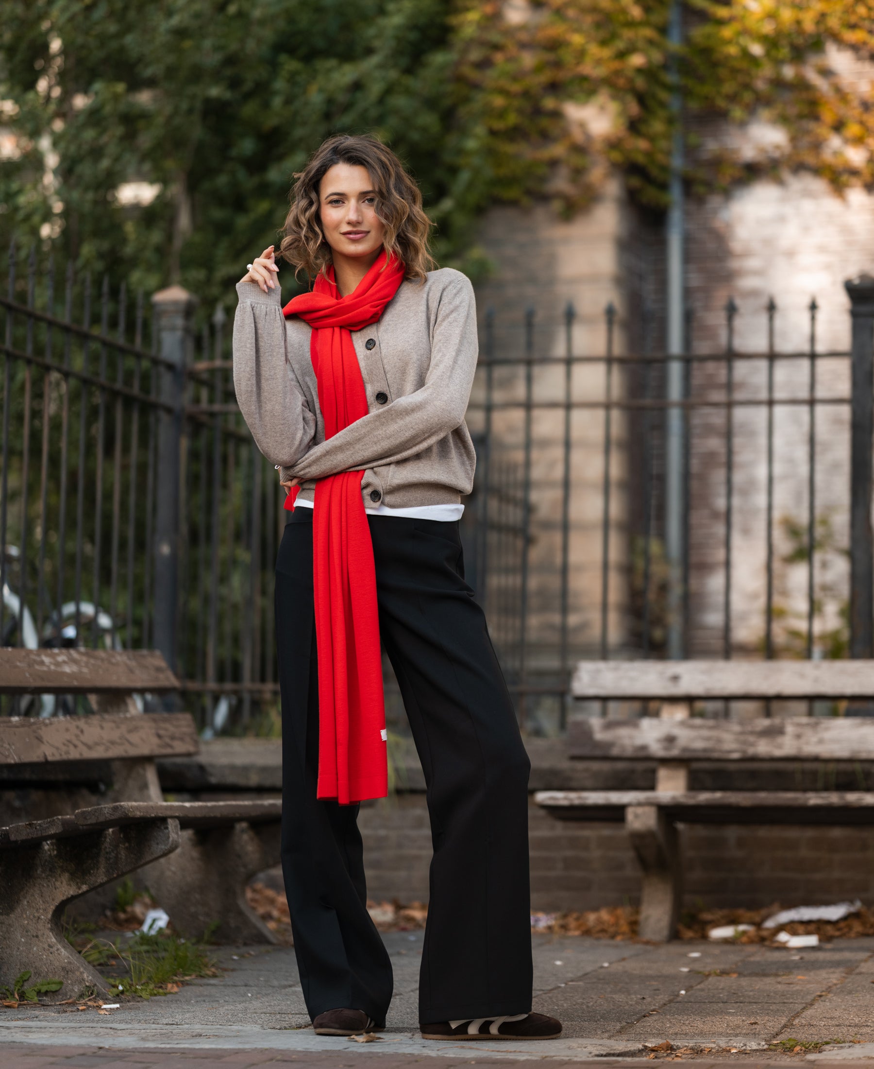 LA BELLA Coral Red Merino wool wrap by PLEIN PUBLIQUE shown outdoors.