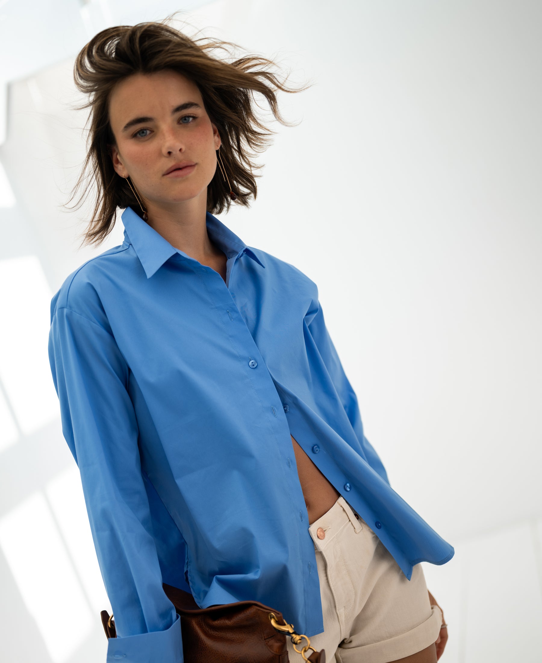 Woman wearing an oversized easy-iron blouse in blue called The Lille.