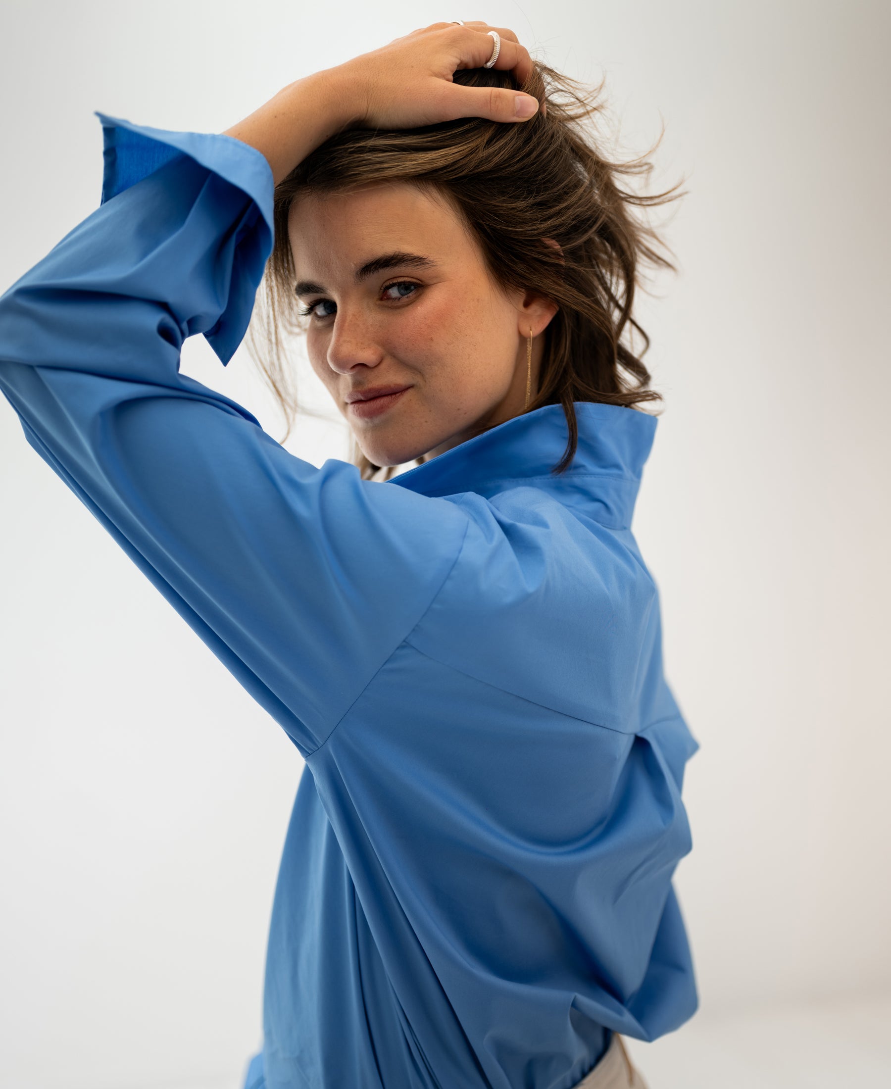 Oversized easy-iron blue blouse, front view, shown on a model against a plain white background.
