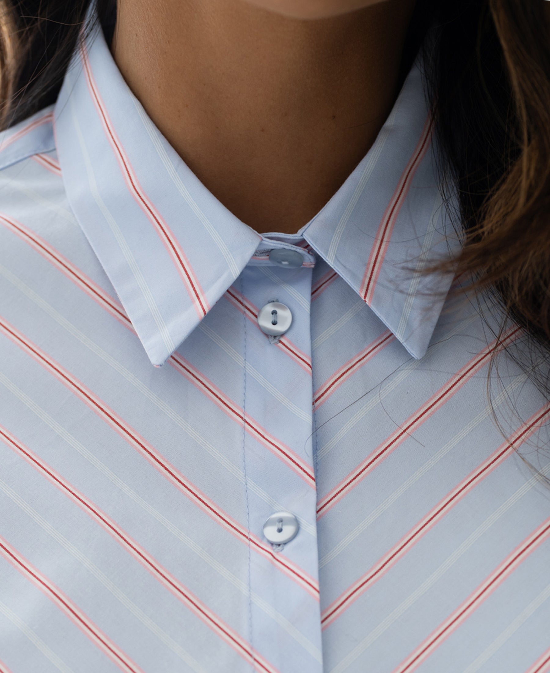 Close-up of the Striped Blouse LA LOIRE in light blue and coral.