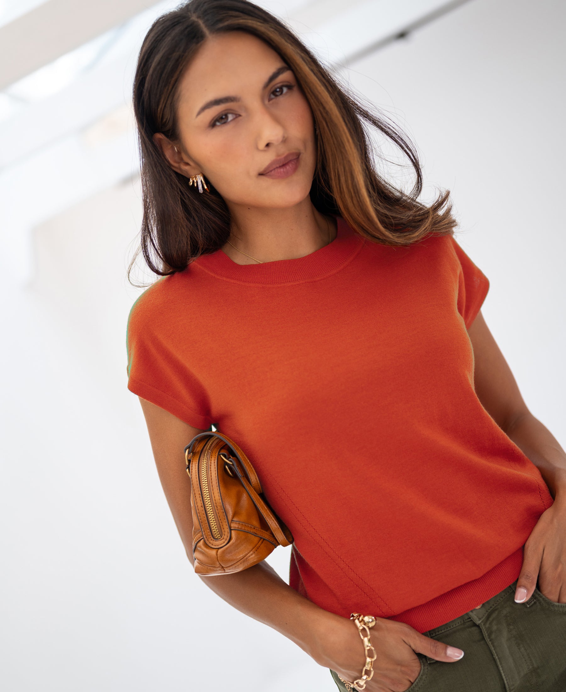 Red merino wool top in a bright, modern indoor space.