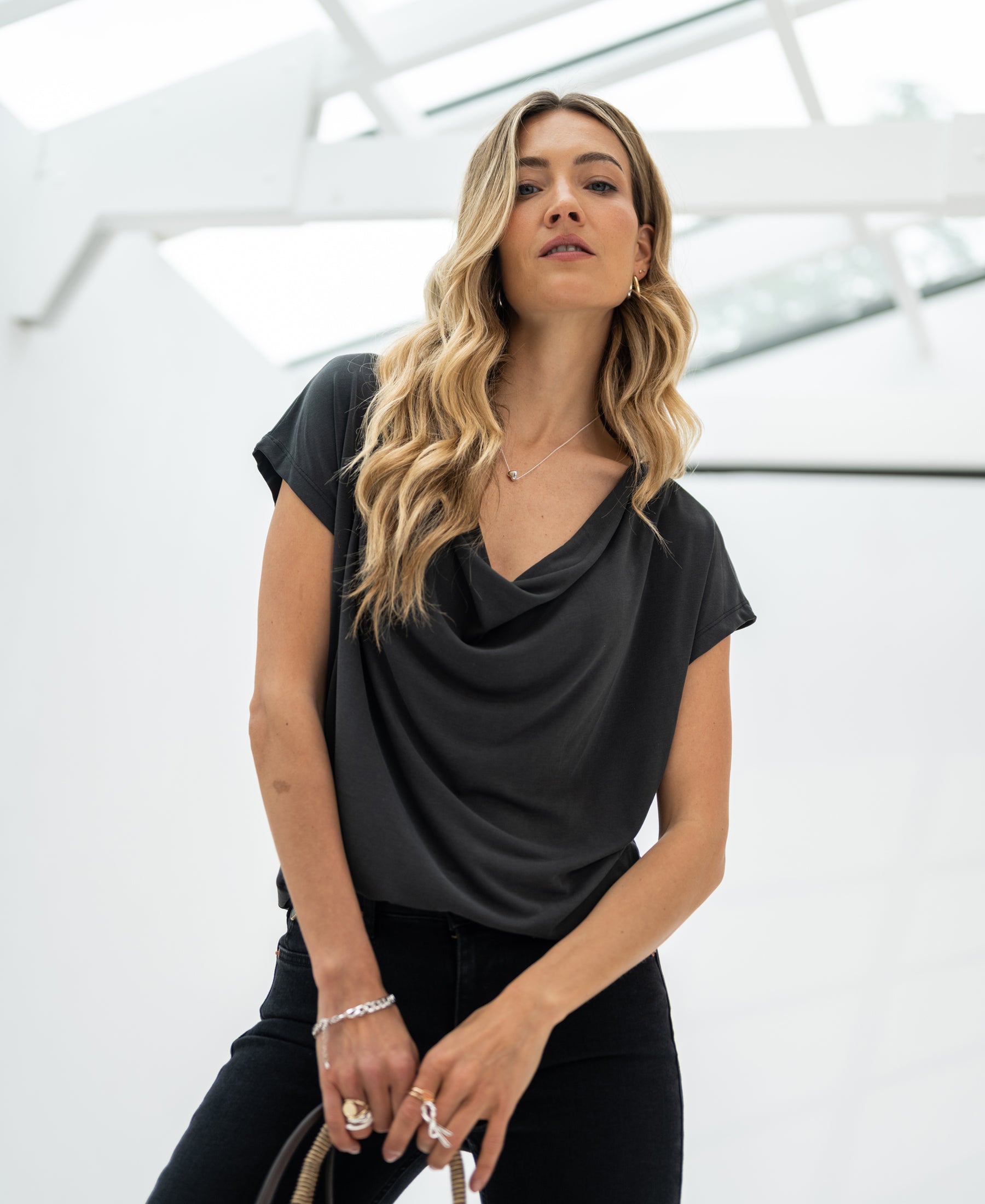 Charcoal gray PLEIN PUBLIQUE LA LUCA draped neckline top, shown on a woman with long blonde hair.