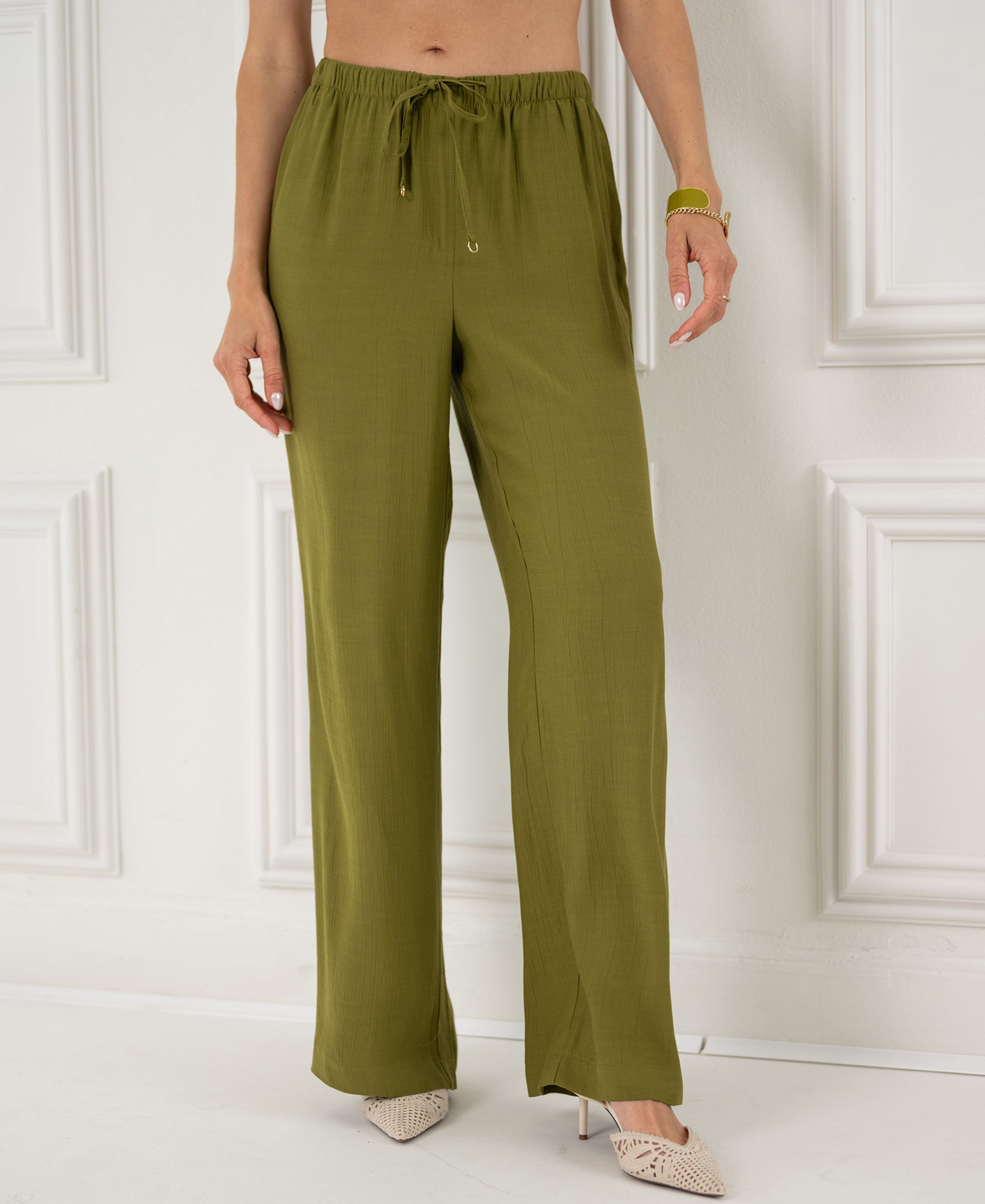 Woman wearing olive green wide-leg pants with elastic waist from PLEIN PUBLIQUE, style LA LYNETTE.