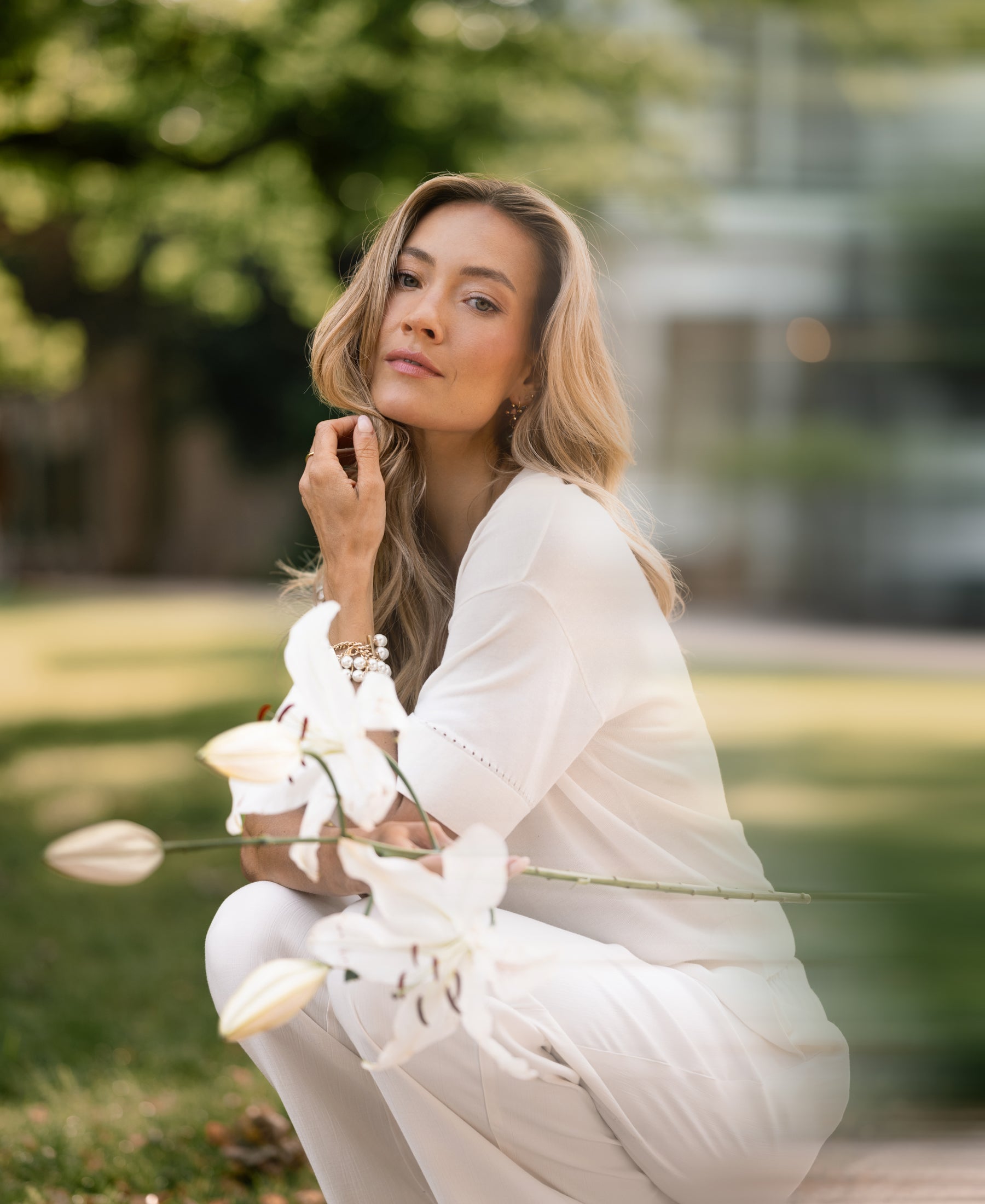 Cream silk top by PLEIN PUBLIQUE, shown outdoors.