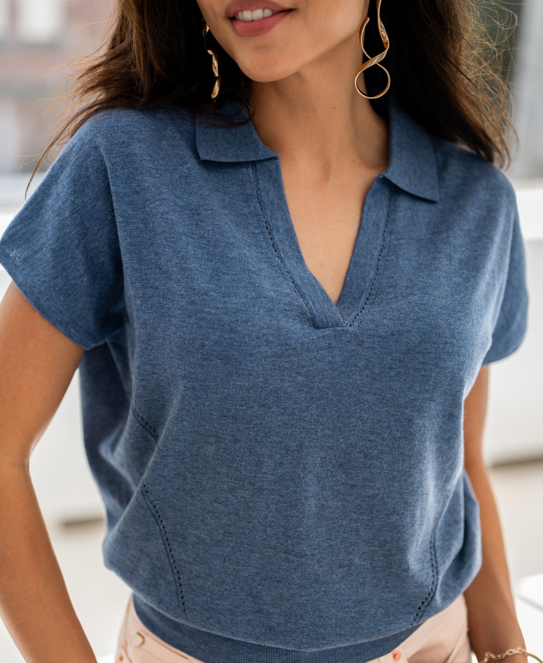Woman wearing a blue Plein Publique LE MARTIN polo neck sweater, indoors.