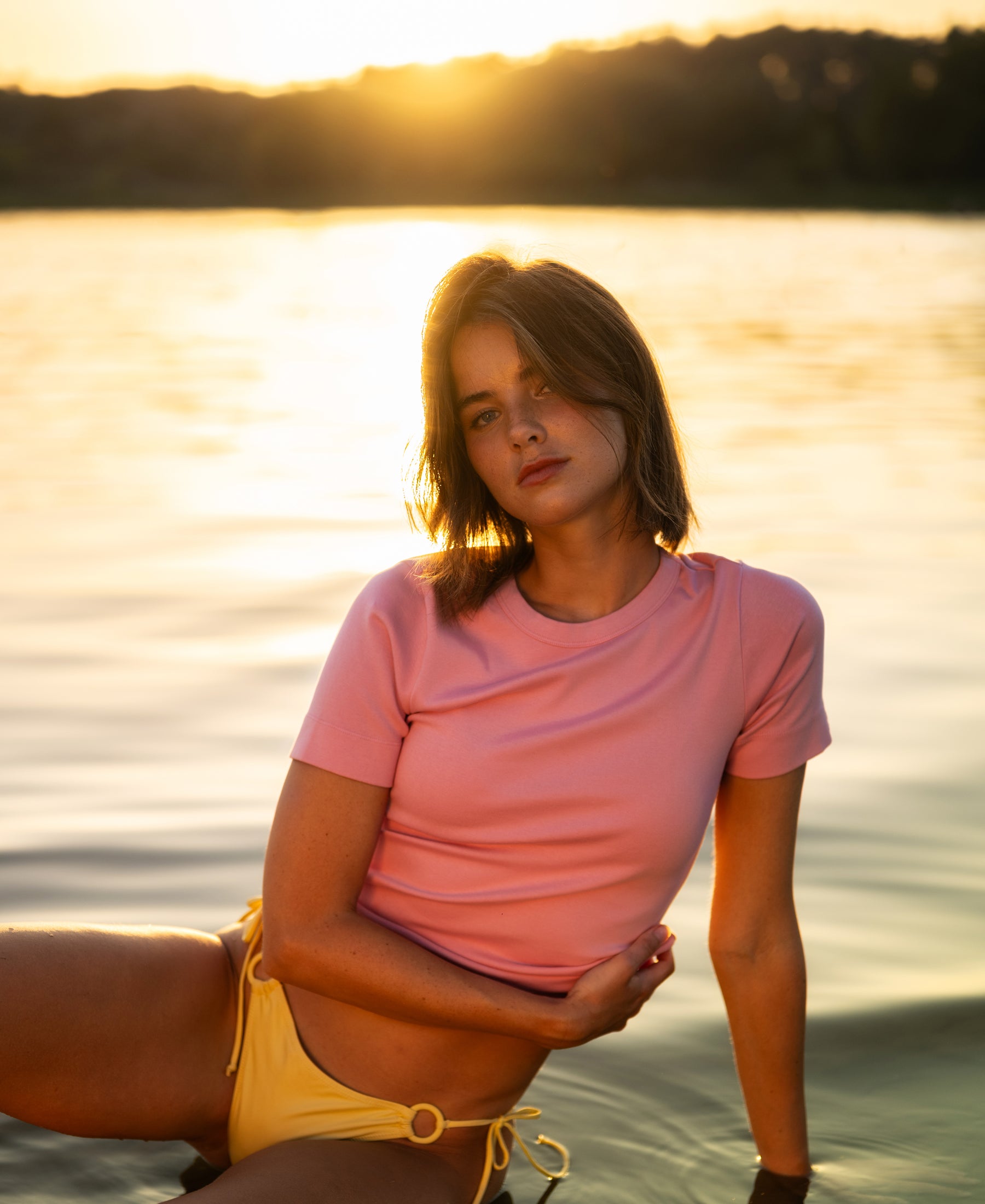 Woman wearing a luxe, soft light pink LA MASSY T-shirt by PLEIN PUBLIQUE.
