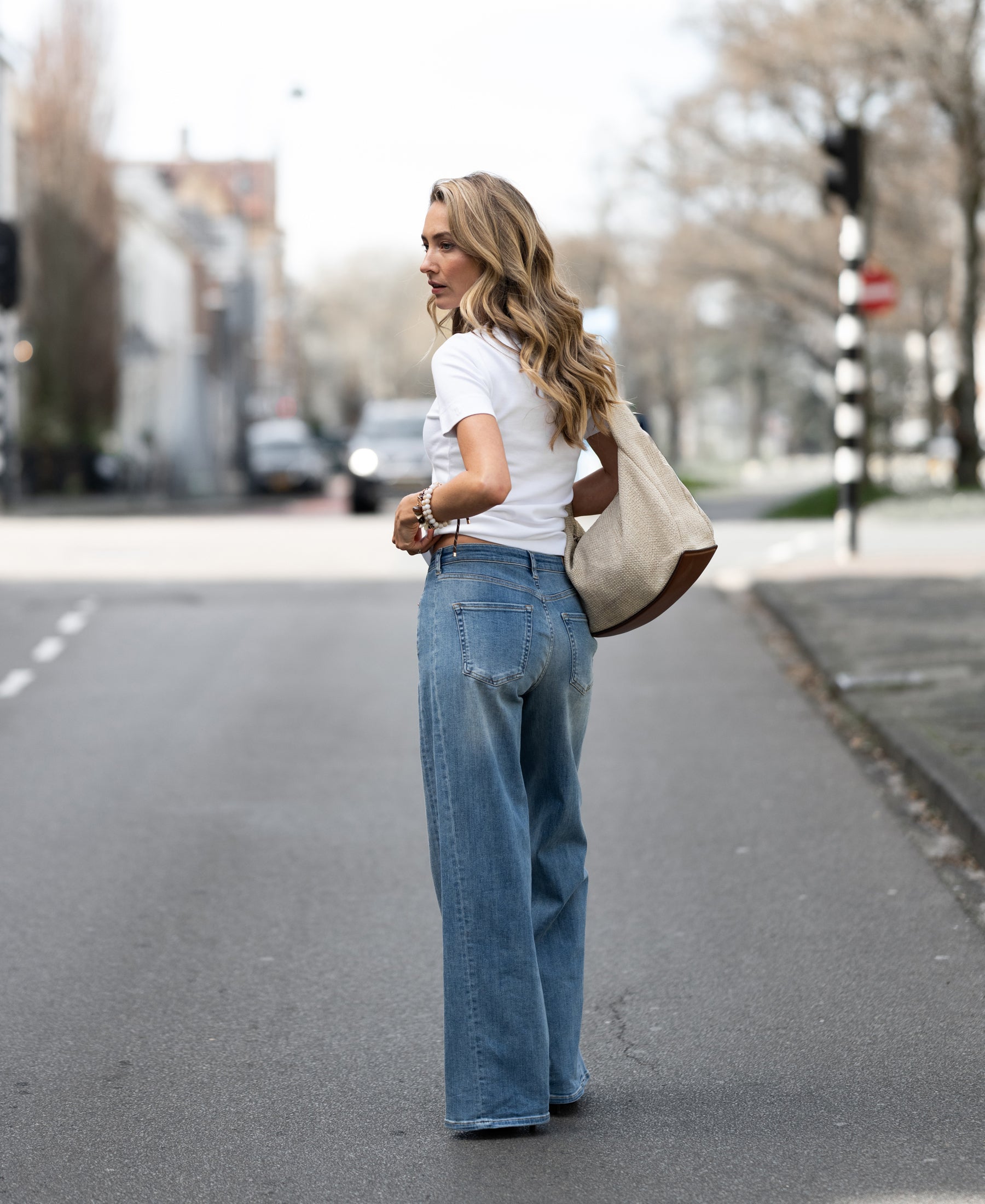 Light stone wide leg jeans with a relaxed fit, shown on a woman.