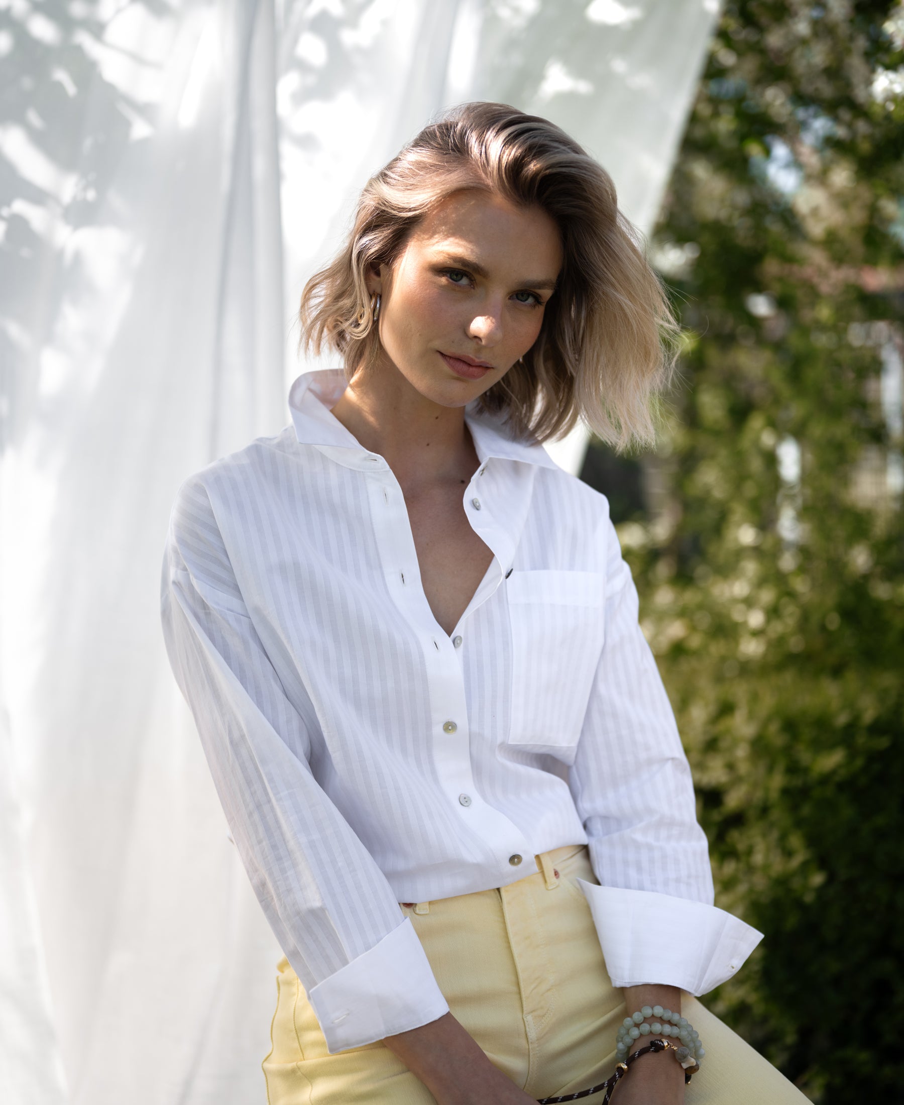 White striped blouse LA PASCALLE displayed outdoors.