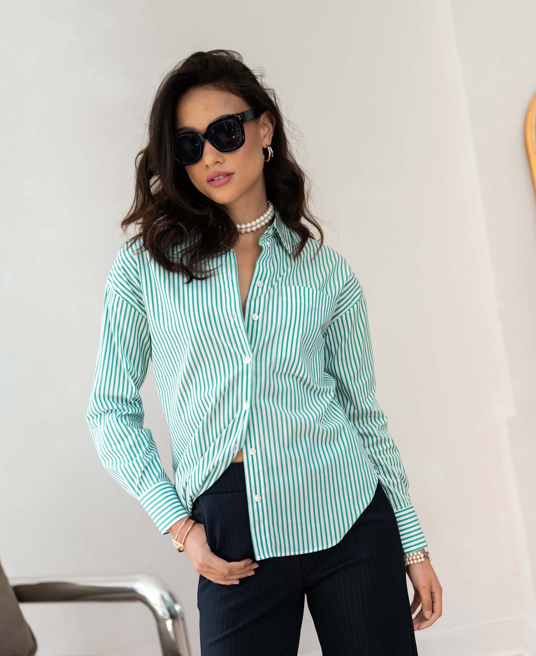 Woman wearing the LA PASCALLE striped blouse in white-green by PLEIN PUBLIQUE, indoors.