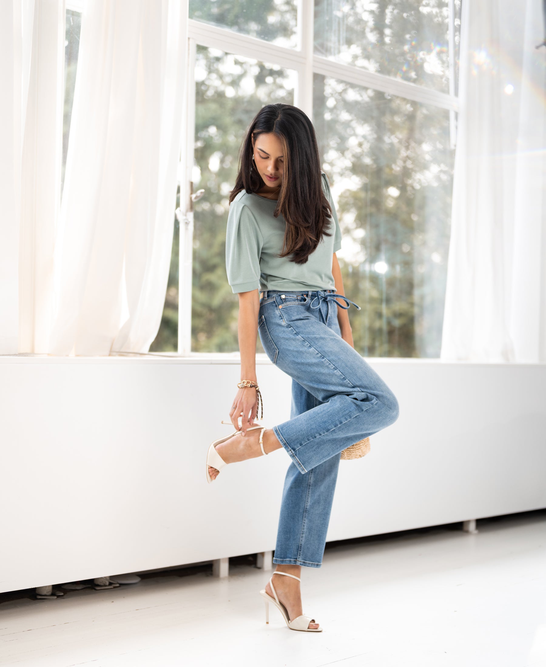 Light green ribbed t-shirt made of cotton, shown worn by a woman in a bright room.