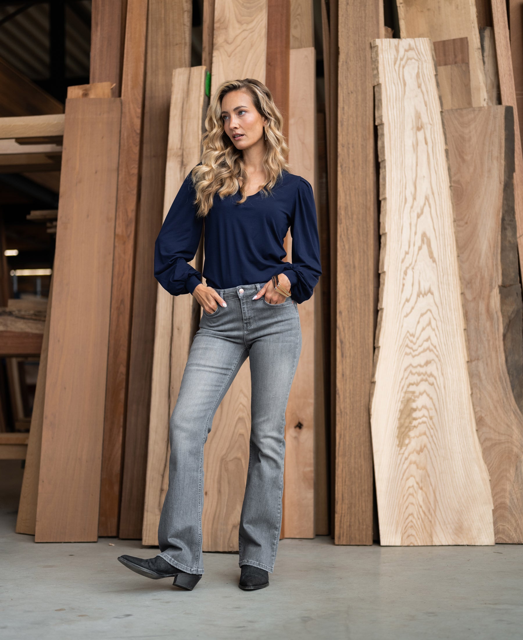 Grey stonewashed flared jeans in a workshop setting.