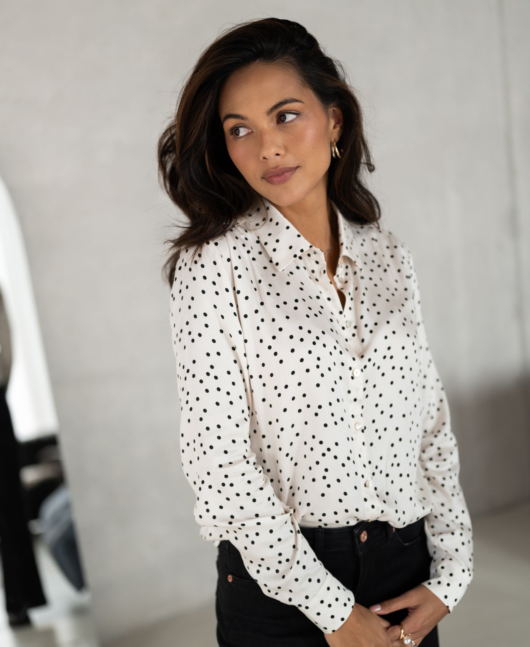 PLEIN PUBLIQUE LA SEZANNE ivory-black polka dot blouse shown indoors.